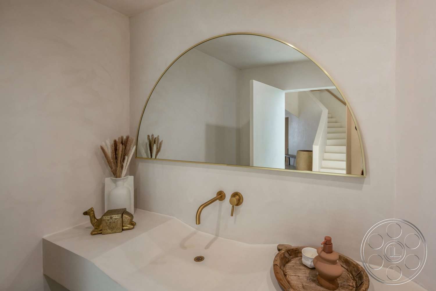 Modern 528 - minimalist decor, neutral color palette, pampas grass arrangement, light wood accents, textured plaster walls, decorative ceramic vase, staircase view, gold faucet fixtures, arched mirror, modern bathroom design, white painted door, curved washbasin countertop, wooden serving tray, open doorway view