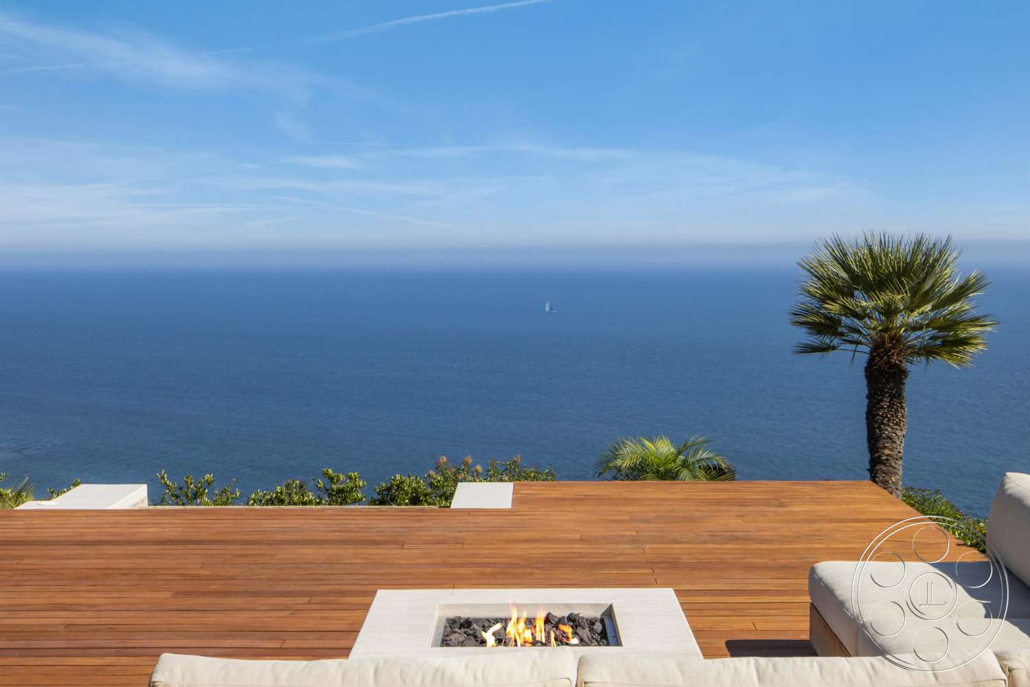 Modern 528 - exterior, clear blue sky, coastal setting, tropical palm trees, contemporary outdoor seating, wood deck flooring, surrounding ocean view, rectangular outdoor fire pit