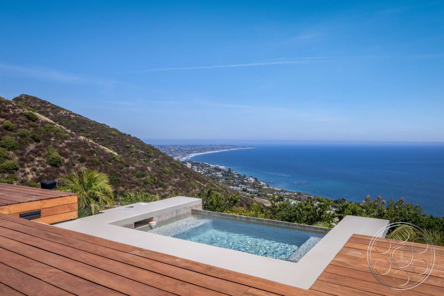 Modern 528 - exterior, glass railing, modern architectural style, ocean view, infinity pool, wood deck flooring, concrete pool border, sloped hillside setting