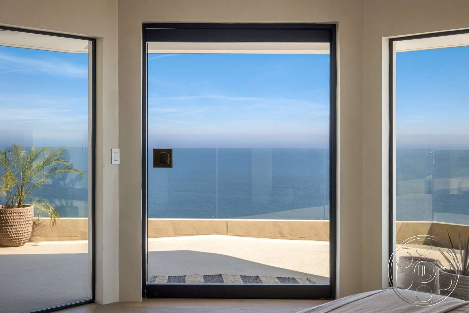 Modern 528 - light wood flooring, floor-to-ceiling windows, ocean view, glass sliding door, natural light-filled space, concrete wall finish, minimalist architectural style, indoor plant in decorative planter