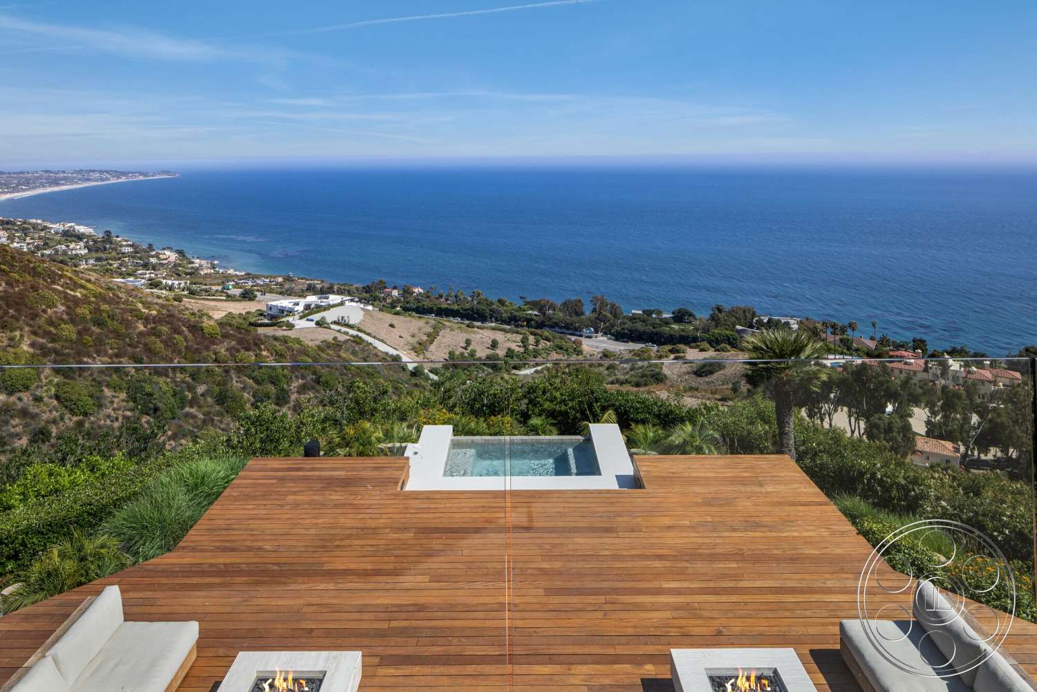 Modern 528 - exterior, outdoor seating area, glass railing, fire pit, ocean view, hillside location, wood deck flooring, landscaped garden surroundings, sunny coastal environment, rectangular hot tub, grass landscape