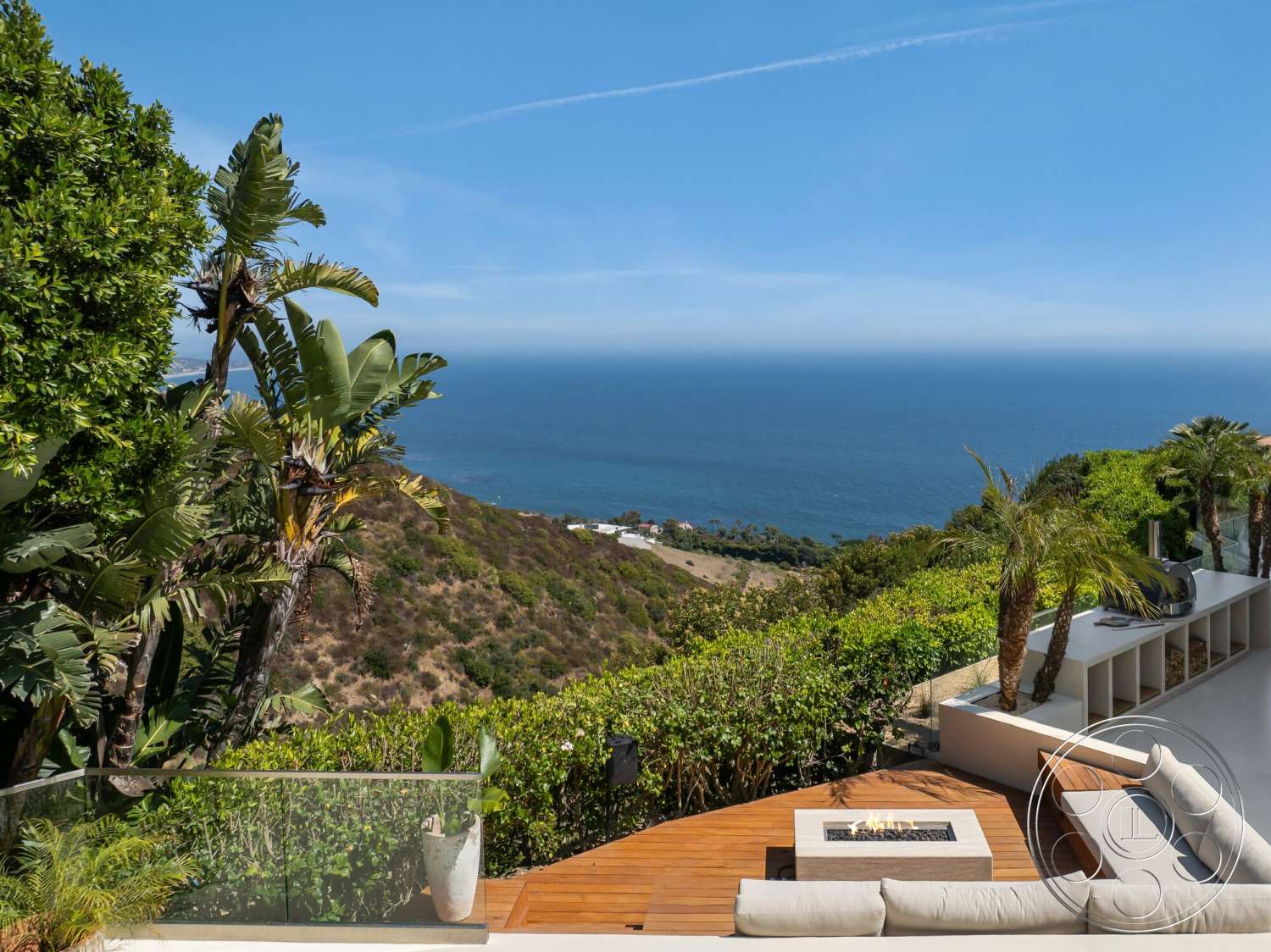 Modern 528 - exterior, metal accents, glass railing, ocean view, tropical palm trees, modern outdoor seating area, wood deck patio, landscape garden setting, built-in outdoor fireplace, stone outdoor kitchen