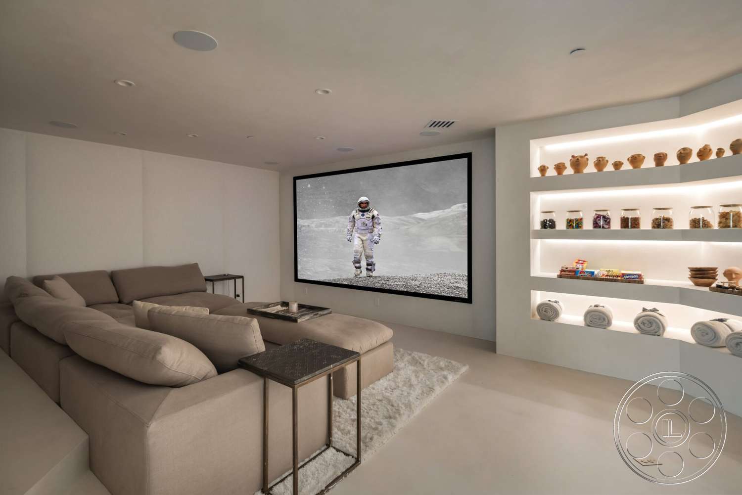 Modern 528 - recessed lighting, concrete flooring, interior living room, textured white plaster walls, cozy area rug, plush upholstered sectional sofa, minimalist shelving unit, light beige fabric sofa, floor-to-ceiling wall-mounted screen, backlit display shelves, decorative jars on shelves, simple coffee table