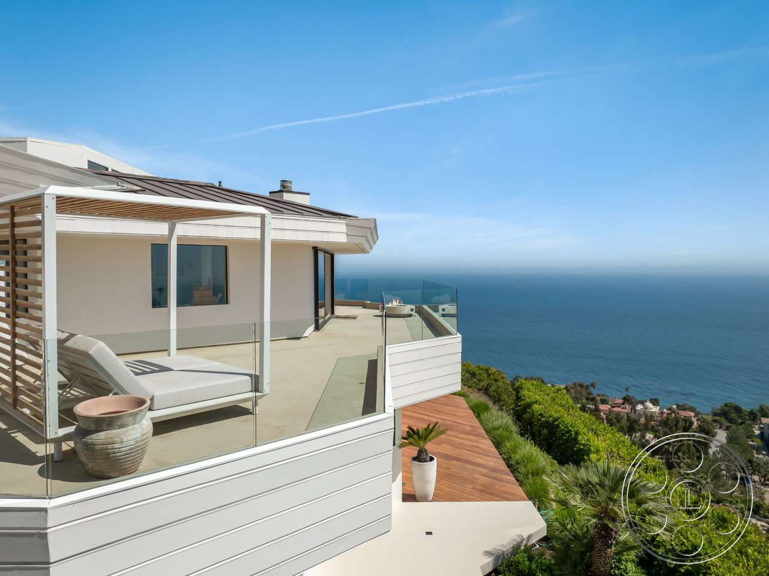 Modern 528 - exterior, flat roof, sliding glass doors, glass railing, coastal view, planter pot, stucco wall finish, wood deck patio, lounging chair