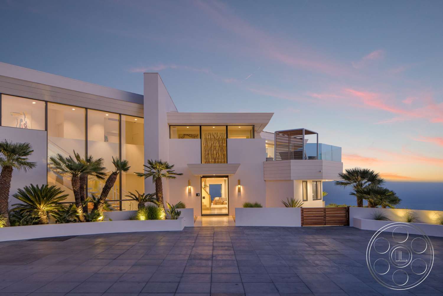 Modern 528 - exterior, modern architecture, minimalist design elements, sunset lighting, concrete driveway, outdoor lighting features, horizontal wood paneling, beachfront view, open entryway, flat roof design, concrete patio flooring, glass window walls, landscaped garden with palm trees, lattice wood deck, sleek lines and geometric shapes