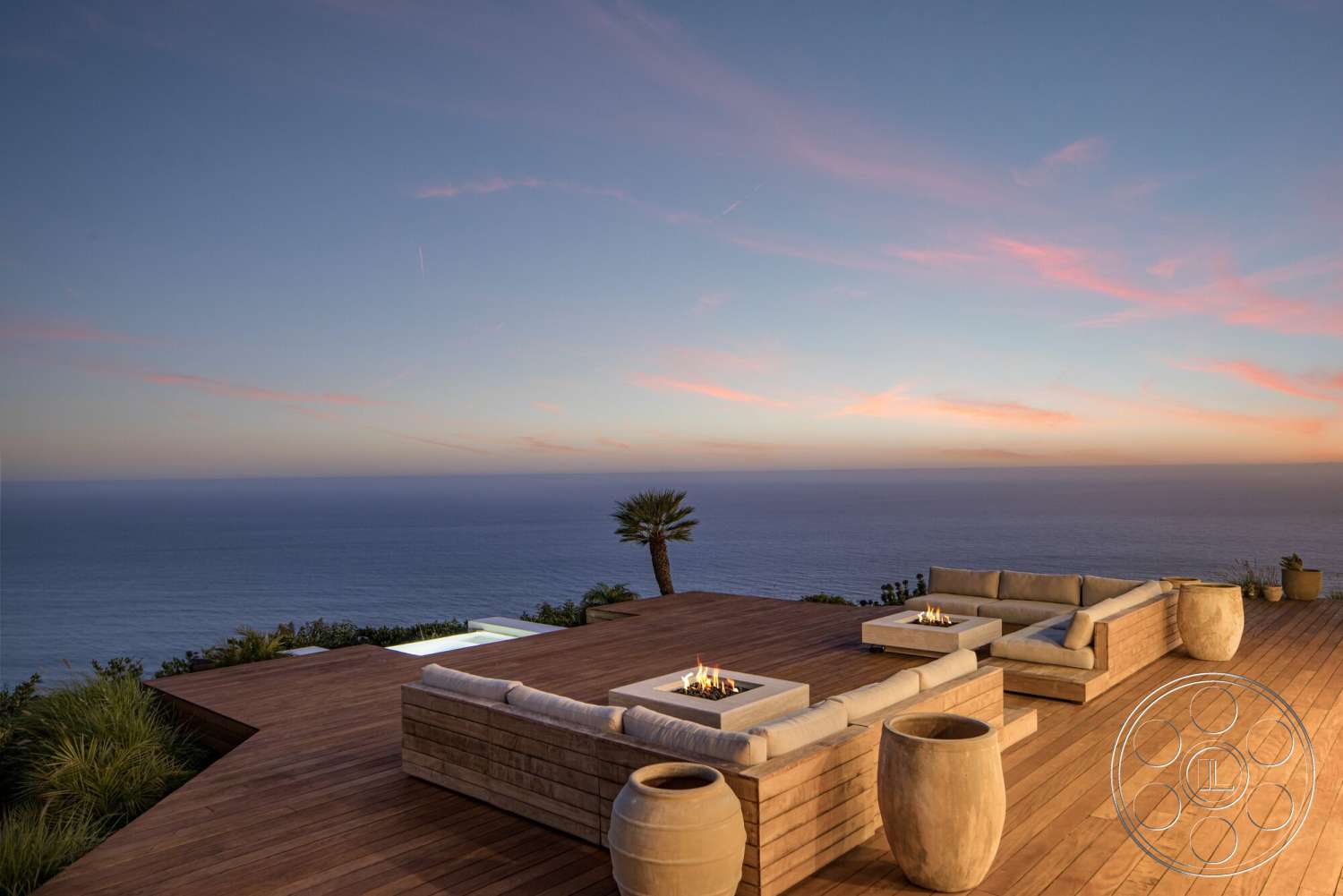 Modern 528 - exterior, contemporary design, modern outdoor furniture, sunset sky, stone fire pit, planter pots, panoramic ocean view, wood deck flooring, palm tree landscaping
