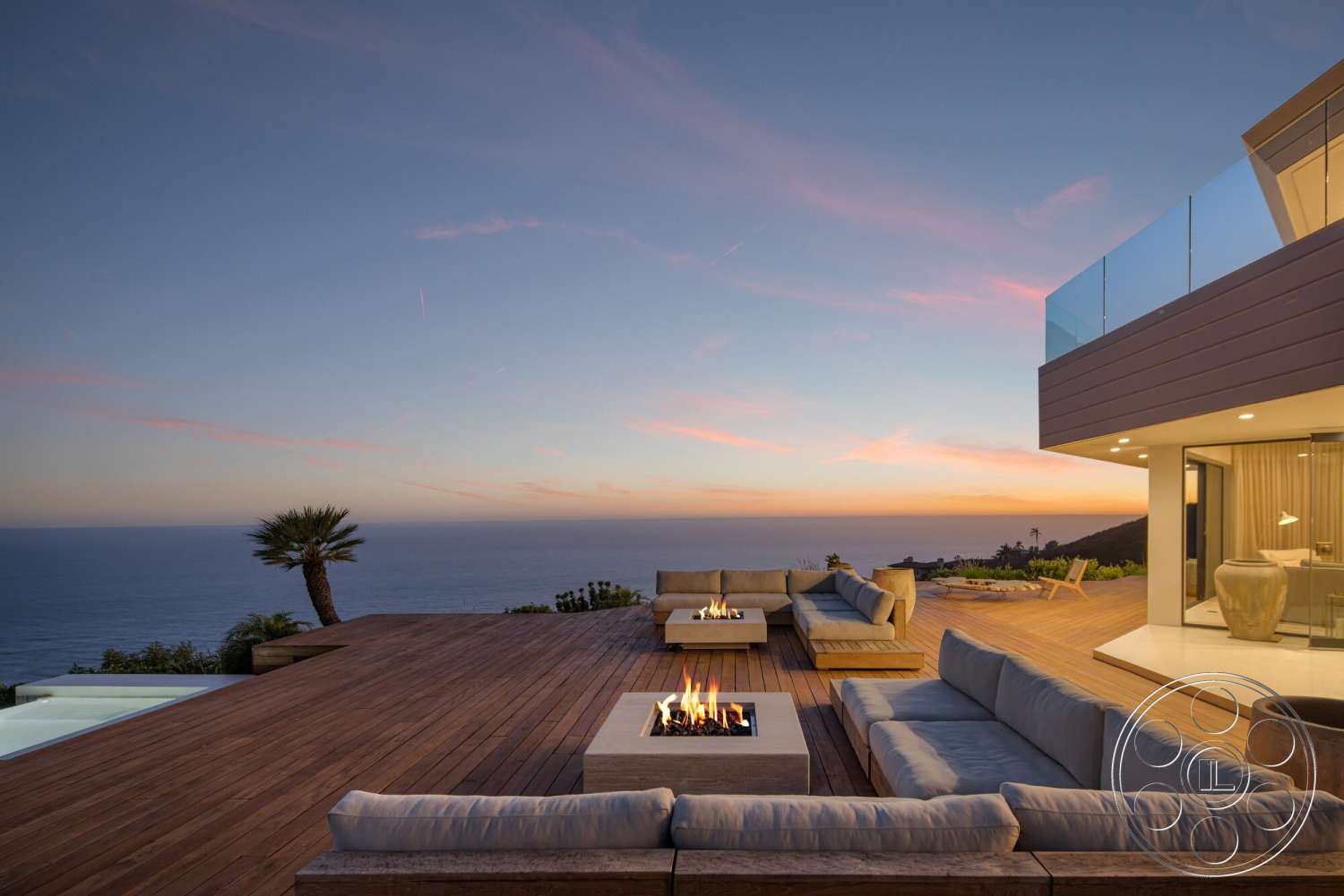 Modern 528 - exterior, landscaped garden, glass railing, ocean view, sunset sky, wood deck flooring, contemporary outdoor lounge area, modern architectural design, rectangular fire pit, stone pool edge, upholstered outdoor sofas