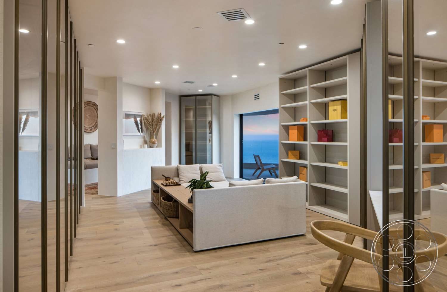 Modern 528 - minimalist decor, neutral color palette, white stucco walls, contemporary furniture, cozy seating arrangement, textured accent wall, ocean view, potted plant decor, floor-to-ceiling glass doors, light wood plank flooring, natural light environment, open plan living area, simple coffee table, custom built-in shelving units, suburban modern home