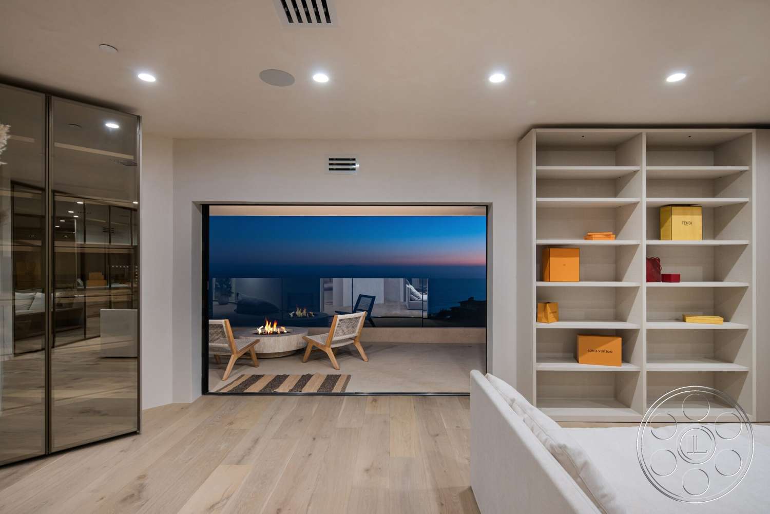 Modern 528 - neutral color palette, open floor plan, sunset ambiance, contemporary outdoor seating, white painted walls, smooth ceiling with recessed lighting, light hardwood living room floors, glass sliding patio doors, minimalist built-in shelving, modern firepit area, horizontal outdoor railing, vast ocean view