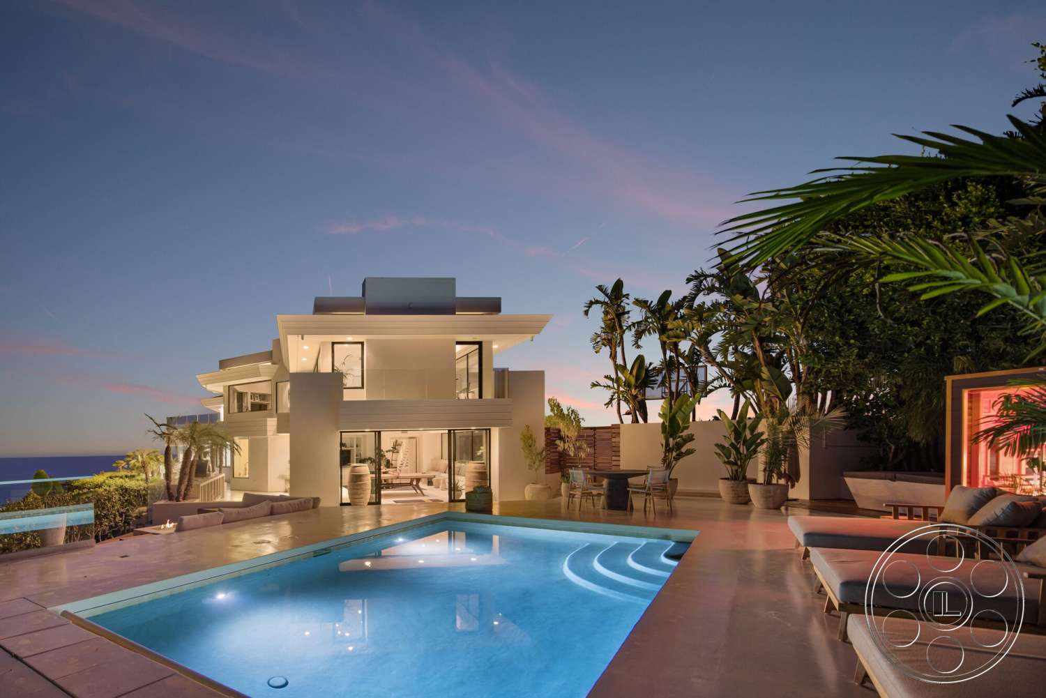 Modern 528 - exterior, landscaped garden, glass sliding doors, metal railings, textured wall panels, sunset view, ocean view, patio seating area, tropical setting, concrete pool deck, rectangular pool, large potted plants, multi-story modern home