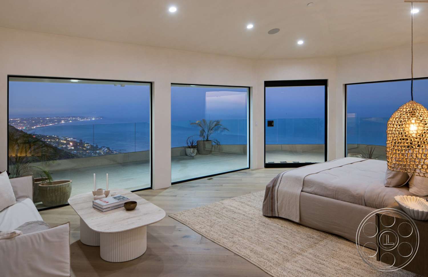 Modern 528 - textured area rug, woven pendant light fixture, interior hardwood bedroom floors, contemporary bedroom design, large floor-to-ceiling glass windows, mountain and ocean view setting, spacious outdoor terrace, open bedroom layout, neutral color wall treatment, minimalist round coffee table, luxury coastal home