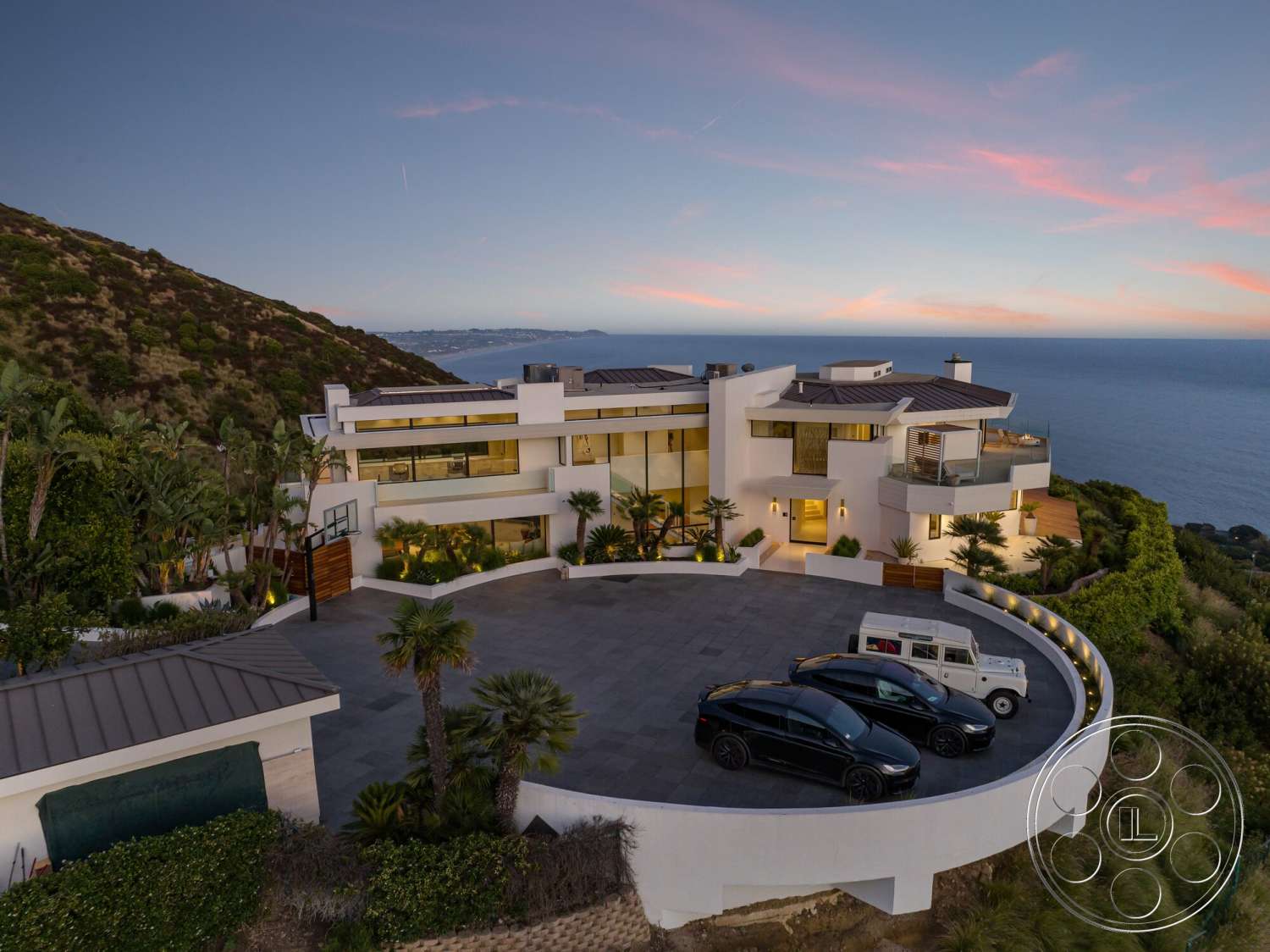 Modern 528 - exterior, landscaped garden, palm trees, slate stone flooring, floor-to-ceiling windows, modern architectural style, curved driveway, stucco walls, open-air terrace, sea view, metal roof, hillside location, round patio area