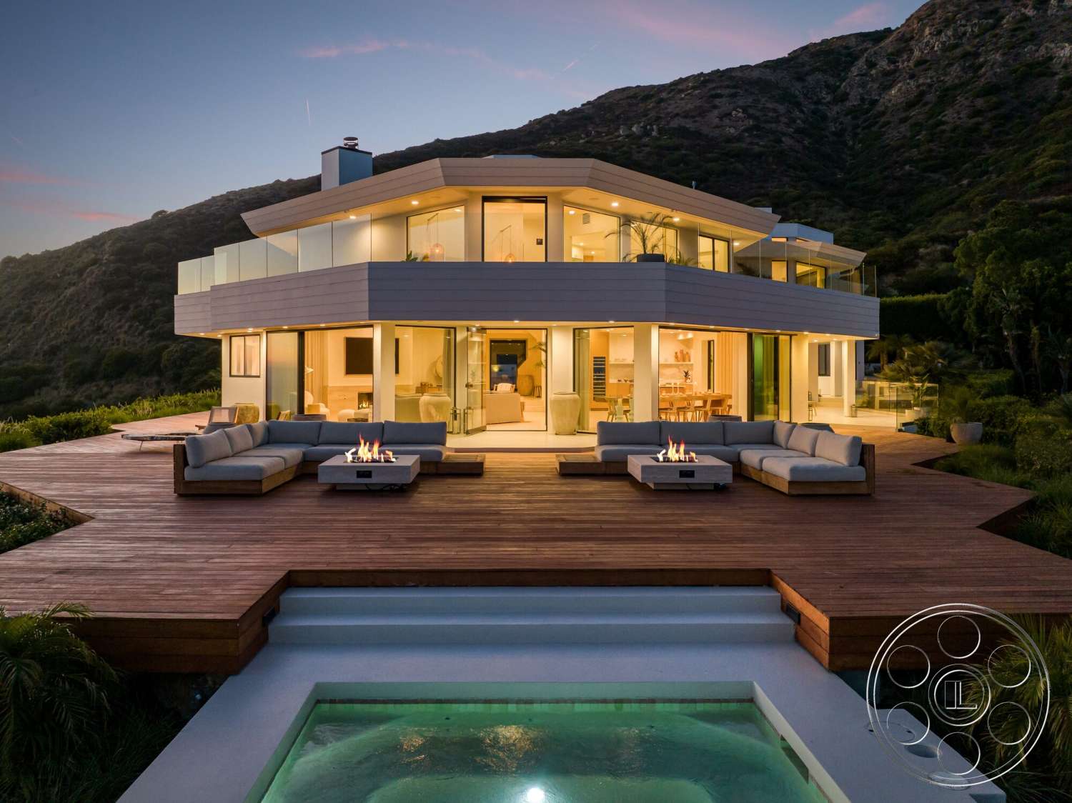 Modern 528 - exterior, outdoor seating area, glass railings, fire pit, rectangular swimming pool, floor-to-ceiling windows, contemporary architecture, grass landscaping, mountain view setting, wood deck patio, multi-level roof