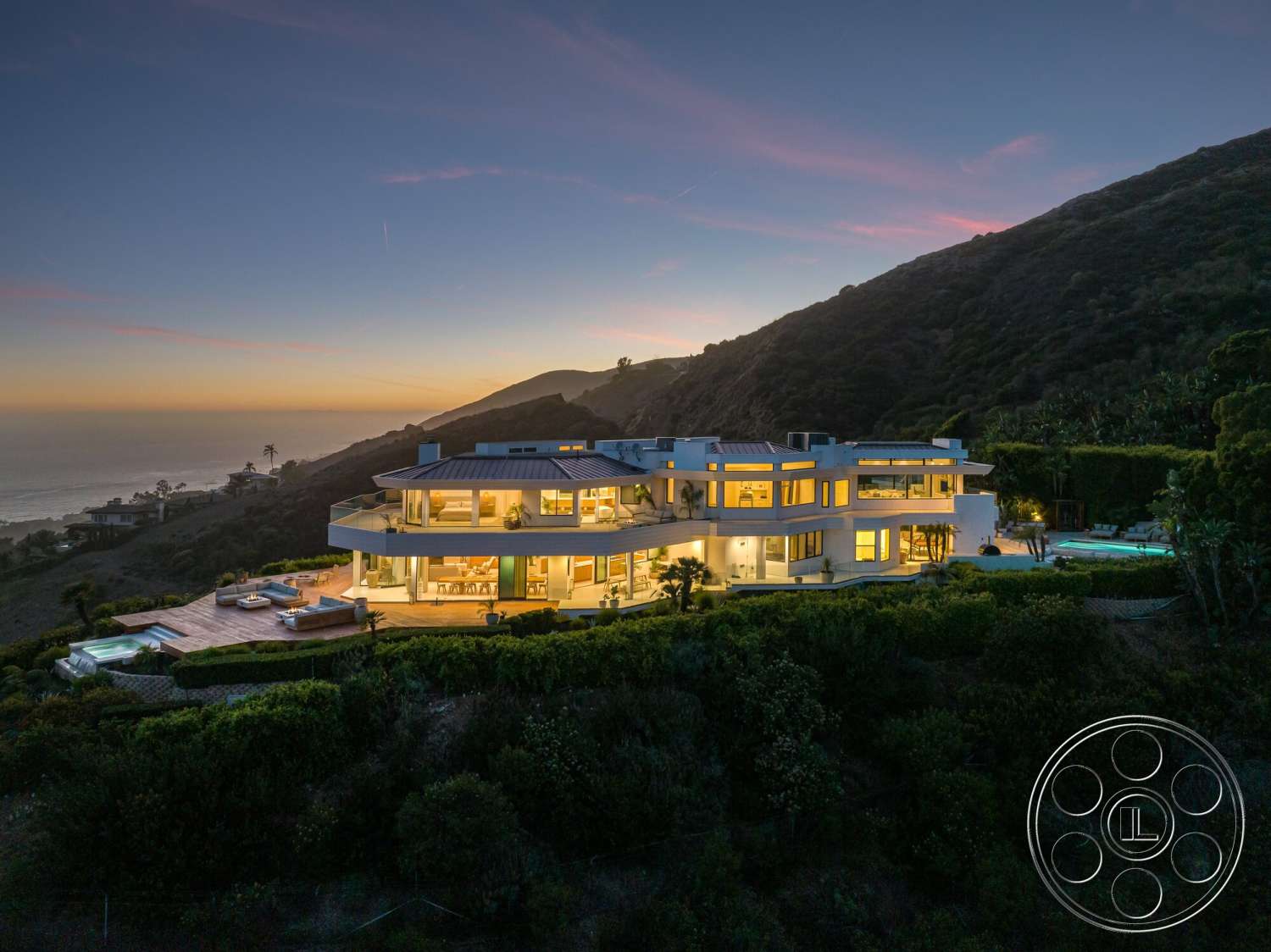 Modern 528 - exterior, large glass windows, outdoor lounge area, modern architectural style, ocean view, concrete driveway, stucco walls, infinity pool, flat roof design, landscaped garden setting, wooden deck patio, mountain hillside location, curved balcony