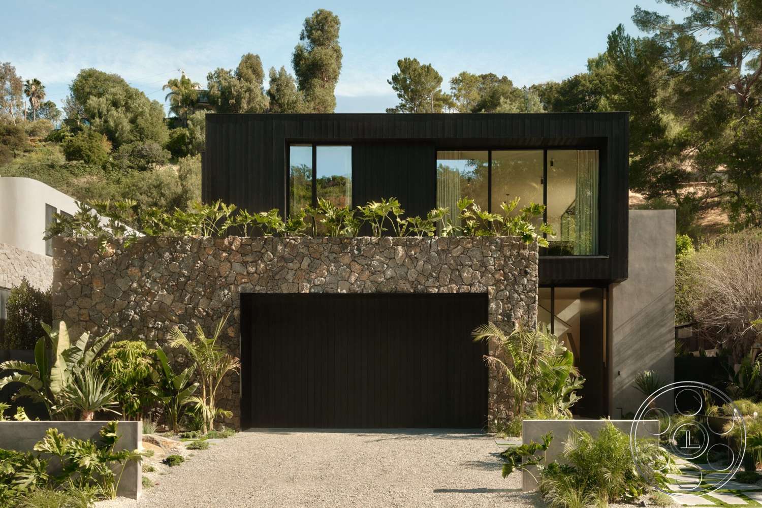 Modern 530 - exterior, minimalist design, lush landscaping, concrete planters, modern architectural style, concrete driveway, large floor-to-ceiling windows, stone facade, two-story house, rectangular shapes, tropical garden setting, black wood cladding, gravel entrance, symmetrical front elevation