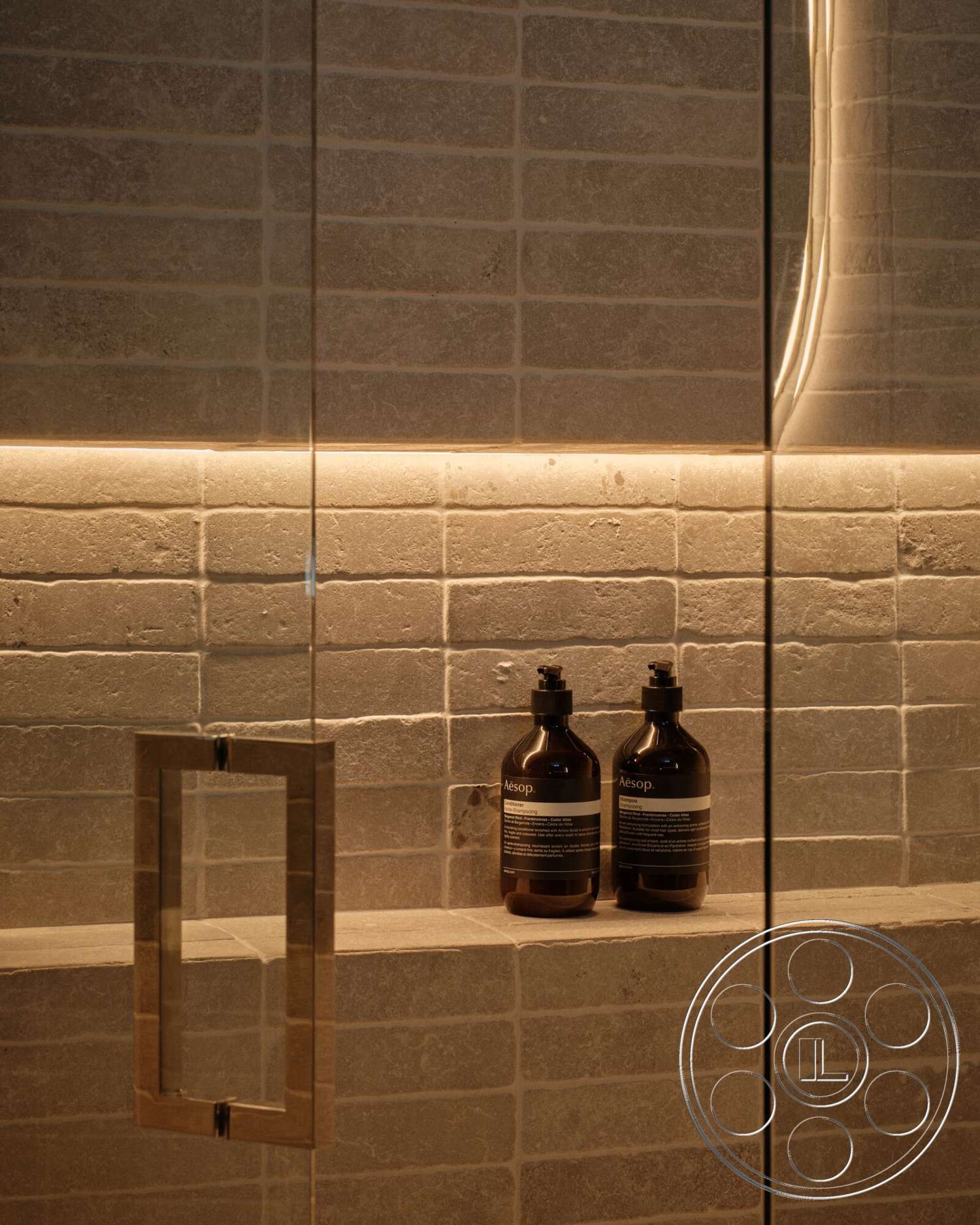 Modern 530 - neutral color palette, minimalist design, ambient lighting, glass shower door, textured plaster bathroom walls, natural stone shelf, steel shower handle