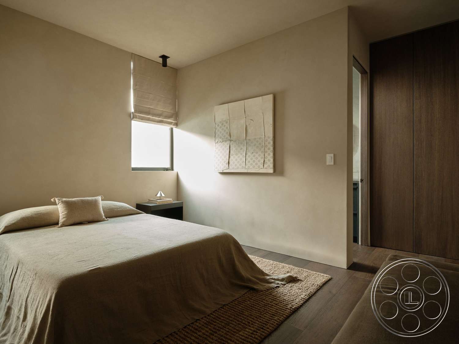 Modern 530 - minimalist design, textured plaster walls, natural fiber area rug, hardwood bedroom floors, framed artwork on wall, white window treatments, modern bed with neutral bedding, dark wood closet doors, stacked wood bedside table