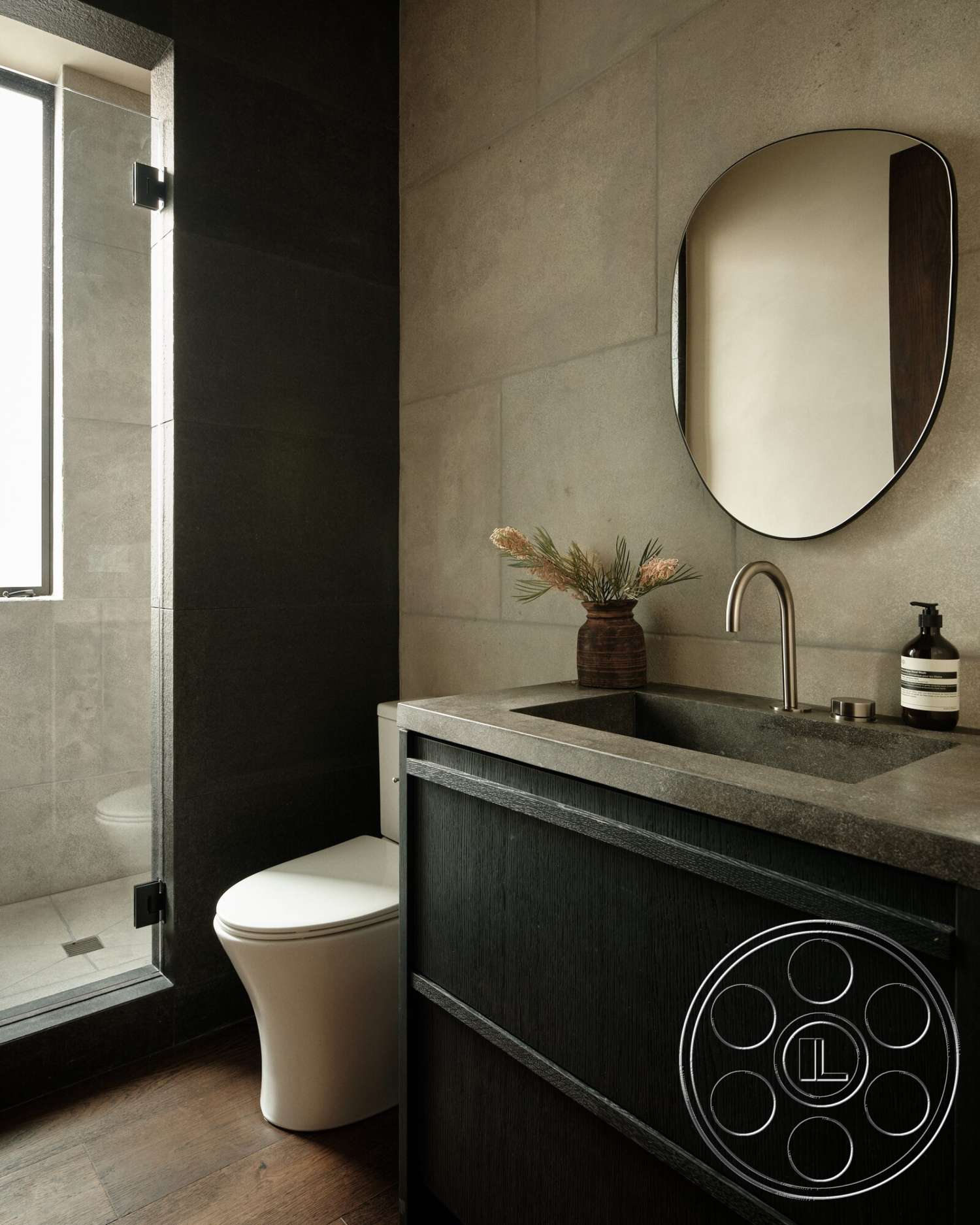 Modern 530 - wood flooring, glass shower enclosure, rectangular mirror, modern faucet, minimalist bathroom design, polished concrete walls, dark stone vanity countertop, black wood cabinetry