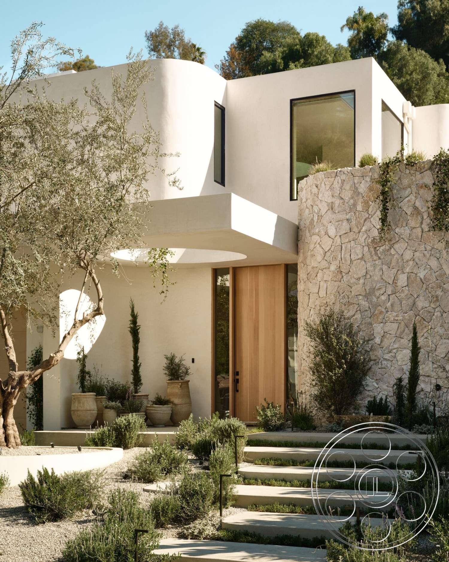 Modern 531 - exterior, low-maintenance plants, large glass windows, curved pathway, concrete steps, stucco walls, textured plaster, earth-tone color palette, minimalist approach, modern architectural design, metal stair railings, natural stone feature wall, landscaped garden with lavender, wood entry door, sleek contemporary lines, olive tree accent