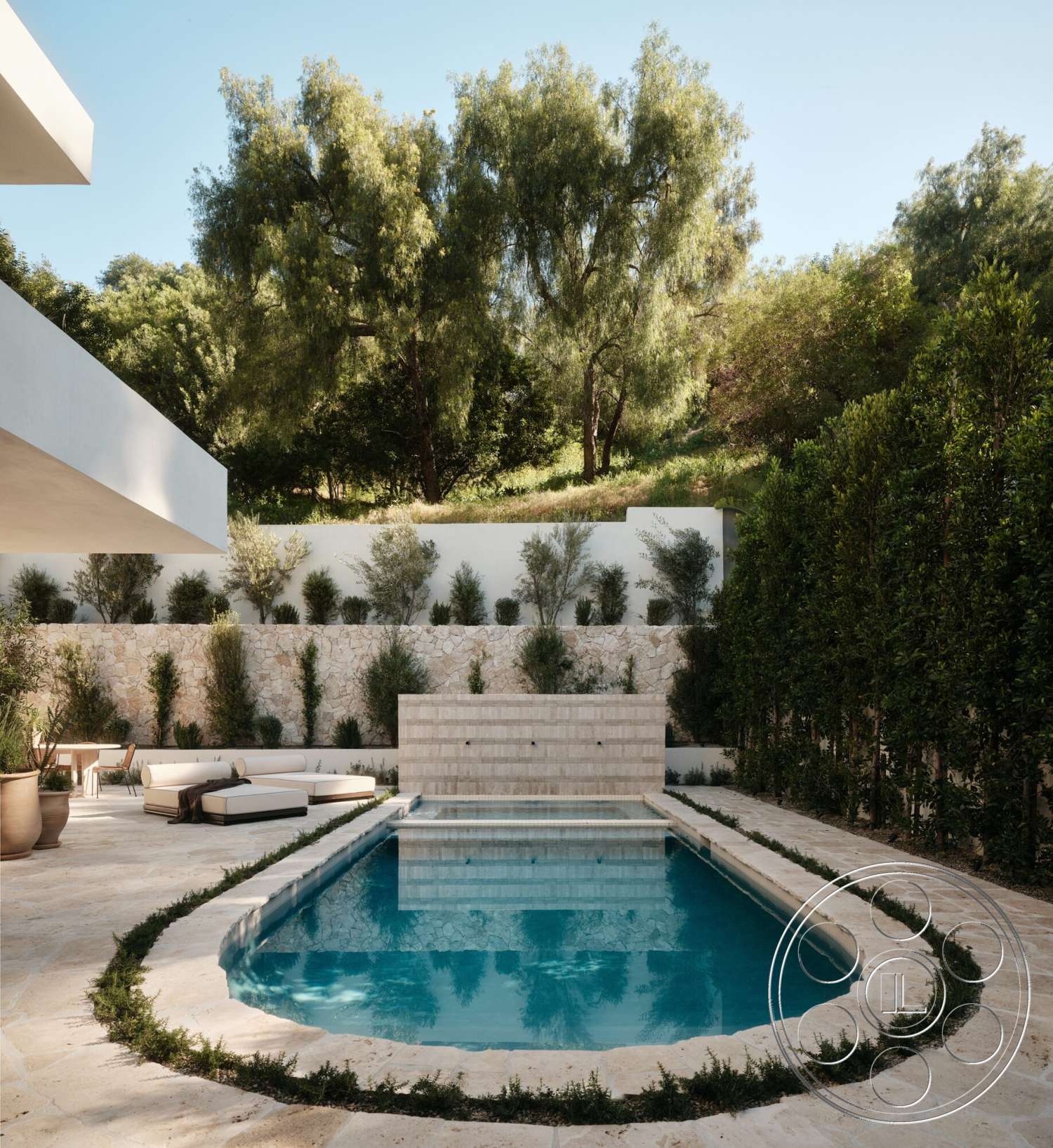 Modern 531 - exterior, rectangular swimming pool, natural stone pool deck, surrounding trees and foliage, tiled pool border, rounded pool edge, decorative stone wall with water feature, paver patio floor, landscape design with low shrubs, outdoor lounge area with modern sectional sofa