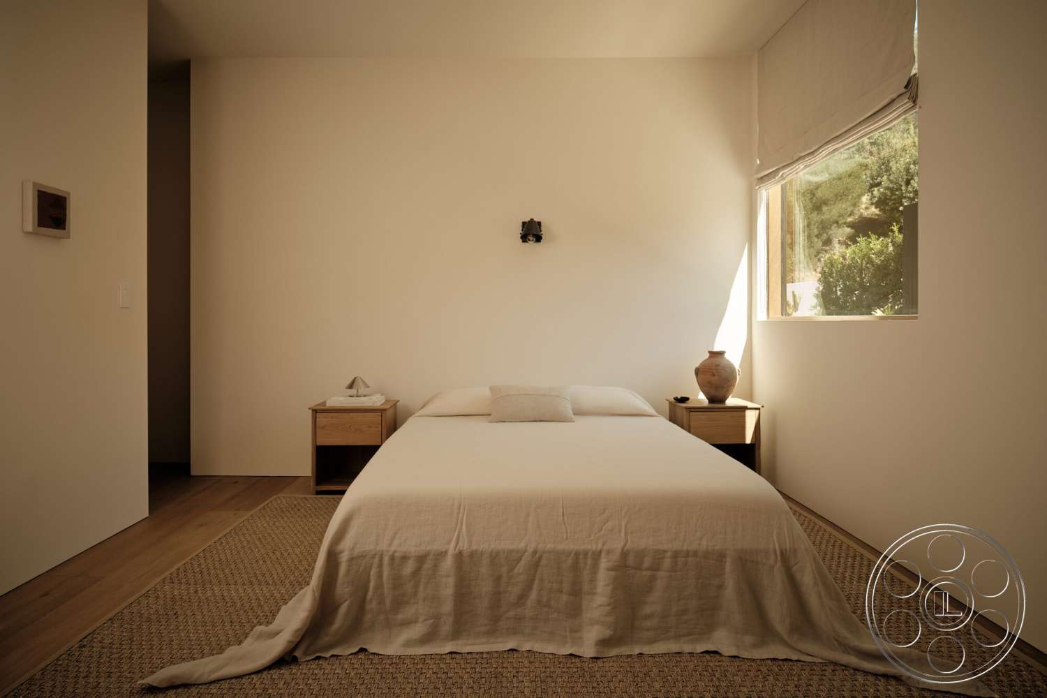 Modern 531 - minimalist decor, neutral color palette, linen bedding, woven area rug, textured plaster walls, hardwood bedroom floors, natural light illumination, rectangular window, simple bedside tables