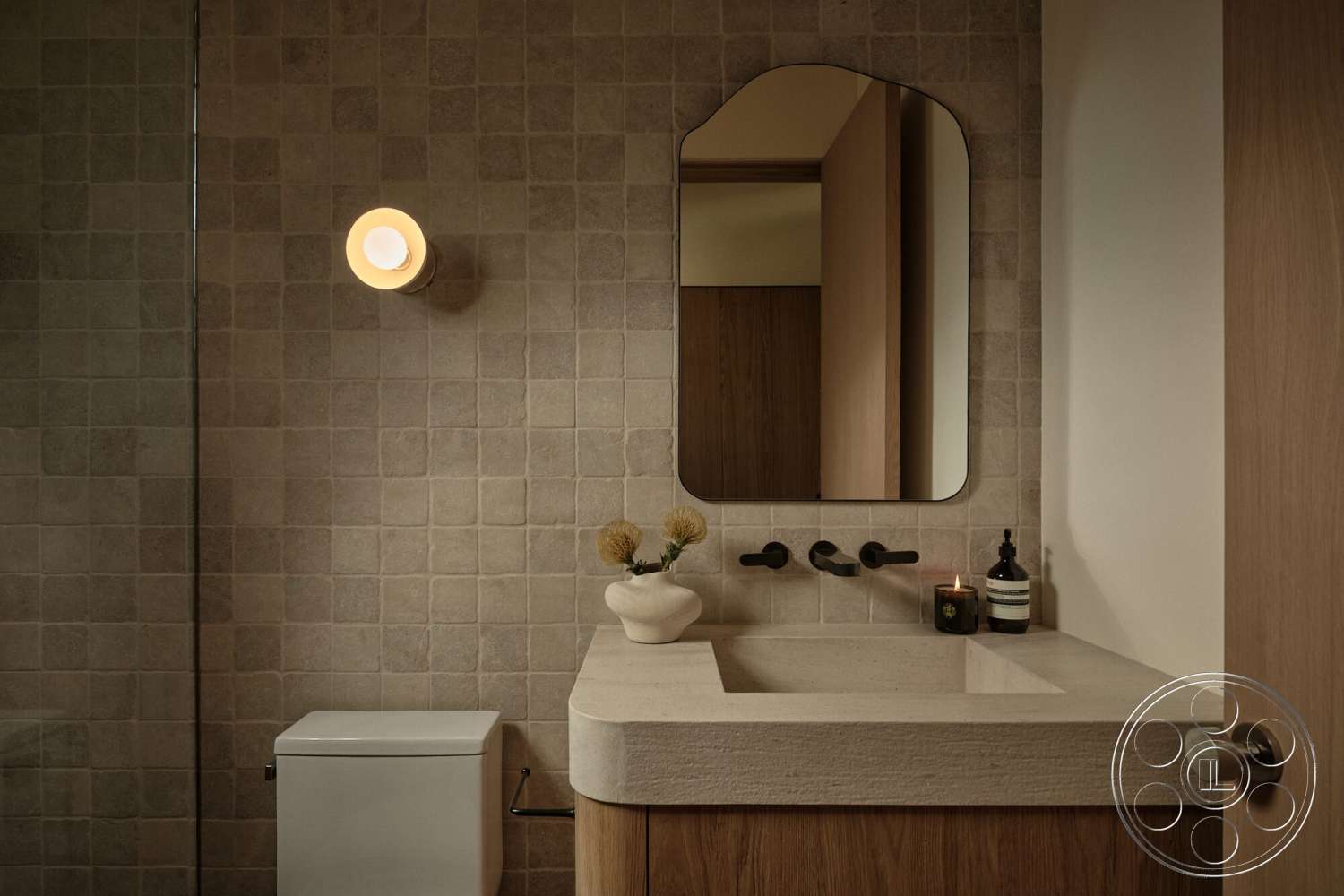 Modern 531 - neutral color palette, minimalist design, wood cabinetry, arched mirror, concrete sink countertop, modern wall sconce lighting, textured tile bathroom walls, black faucet fixtures
