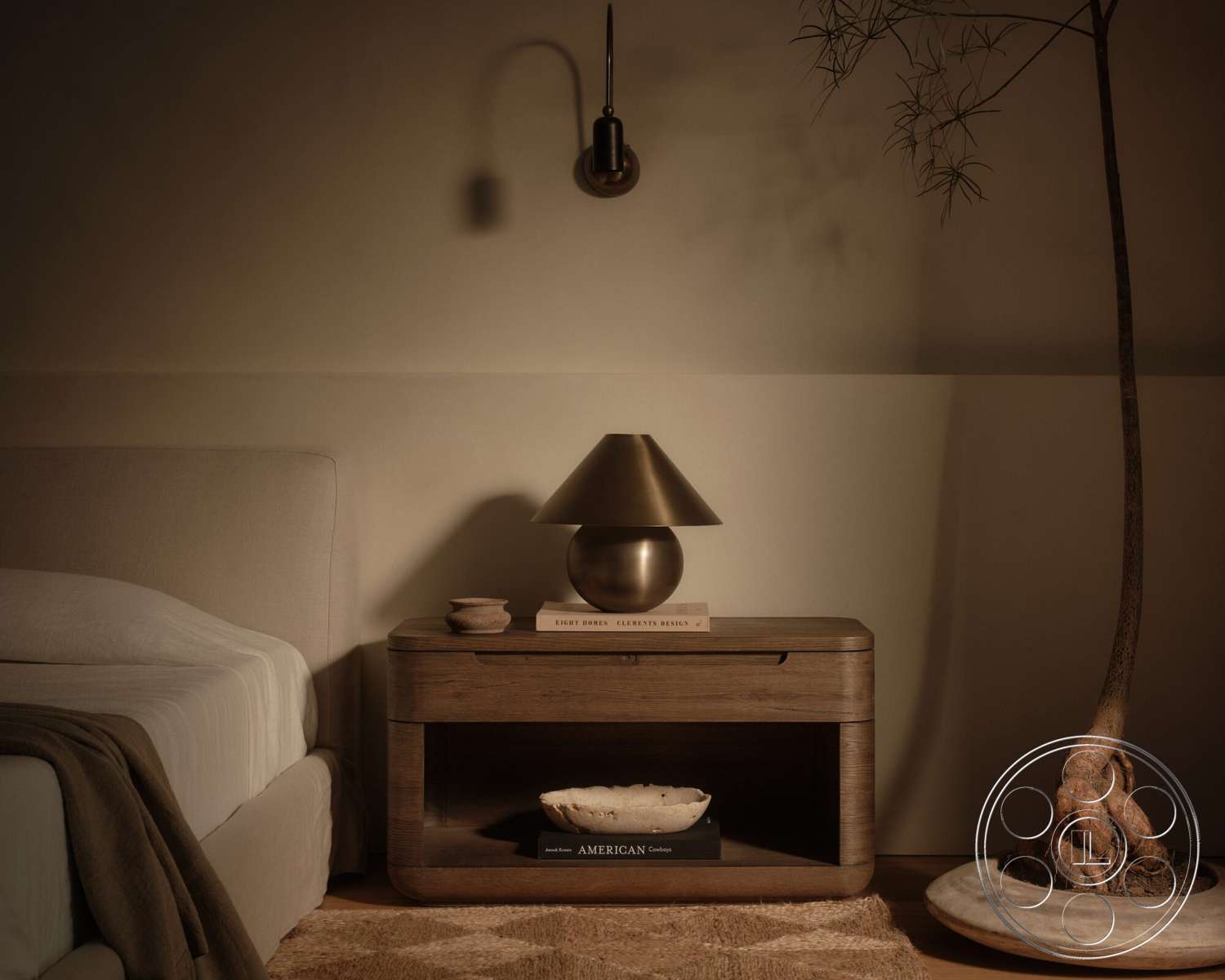 Modern 531 - wooden flooring, small potted plant, woven area rug, textured plaster walls, light brown bedding, modern minimalist design, king-size bed with upholstered headboard, wood nightstand with open shelf, metal table lamp with conical shade, decorative bowl on nightstand, framed books on nightstand