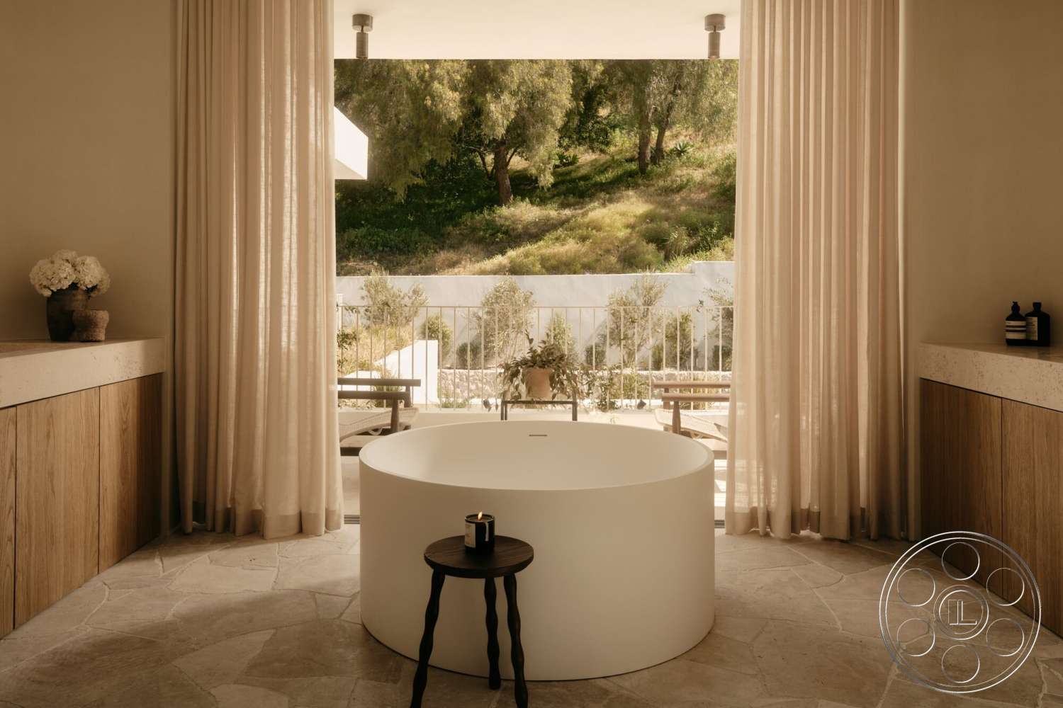 Modern 531 - natural light, wood cabinetry, floor-to-ceiling windows, textured stone flooring, modern minimalist design, surrounding greenery view, oval freestanding bathtub, sheer fabric curtains, smooth white countertop
