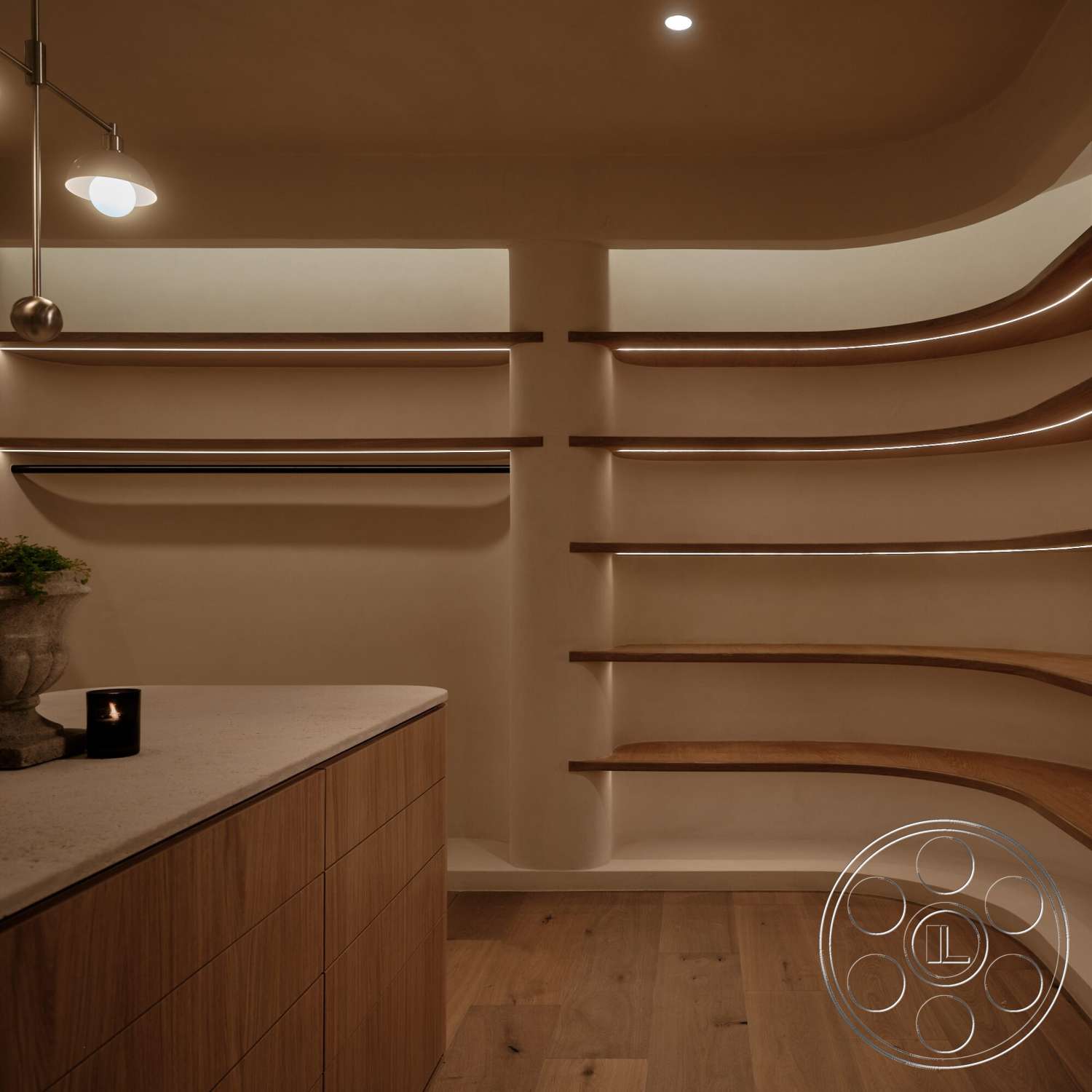 Modern 531 - light wood cabinetry, warm wood flooring, textured plaster walls, ambient recessed lighting, curved wooden shelving, white cement countertop, soft indirect lighting