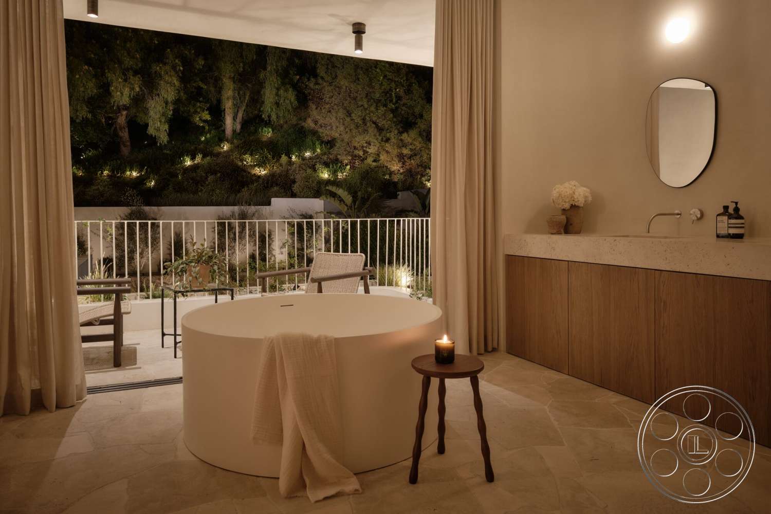 Modern 531 - ambient outdoor lighting, lush garden view, floor-to-ceiling sheer curtains, serene spa-like atmosphere, outdoor seating area with wooden chairs, freestanding round bathtub, textured beige stone flooring, wood vanity with warm wood grain, minimalist round mirror, modern candle holder, concrete patio railing