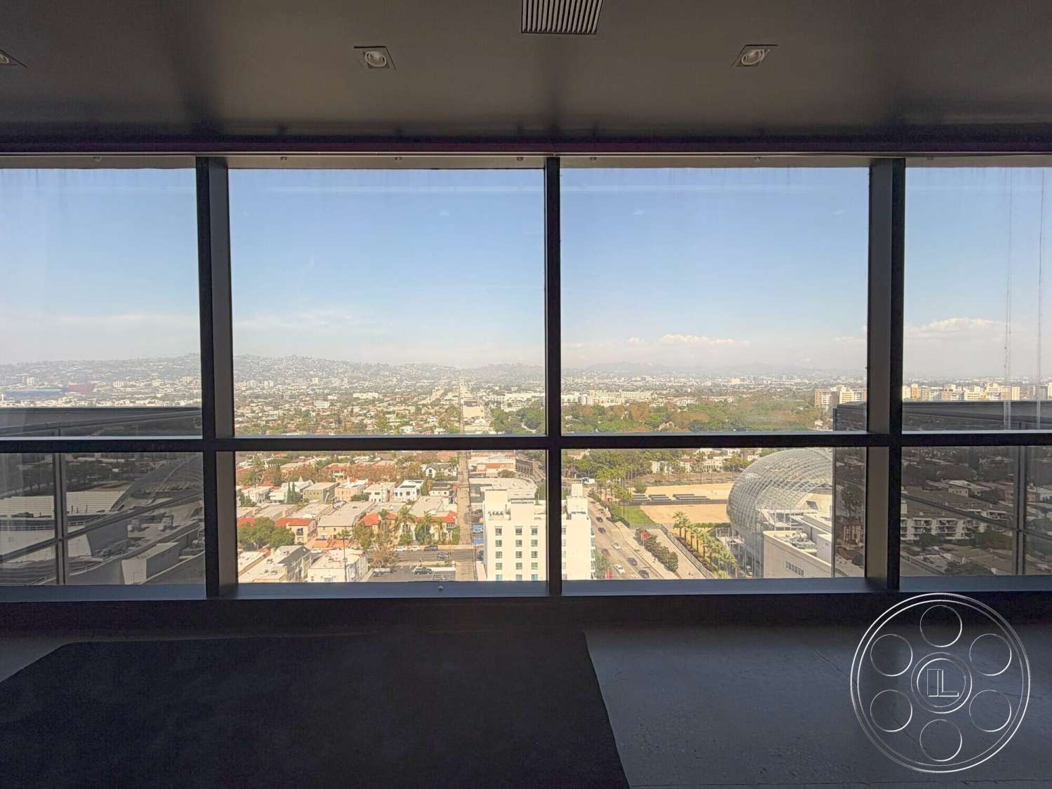 Wilshire Penthouse - polished concrete floor, floor-to-ceiling windows, modern architectural style, urban skyline view, light-filled space, city balcony