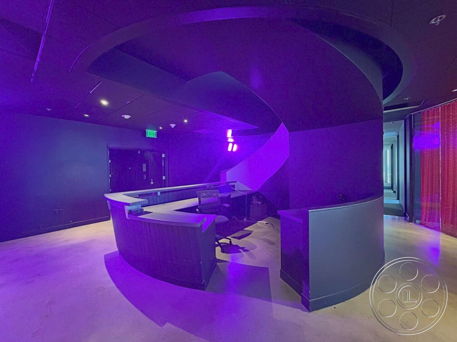 Wilshire Penthouse - minimalist decor, polished concrete floor, modern architectural design, smooth surface finishes, ceiling-mounted lighting fixtures, curved reception desk, dark purple wall treatment, ambient lighting effects