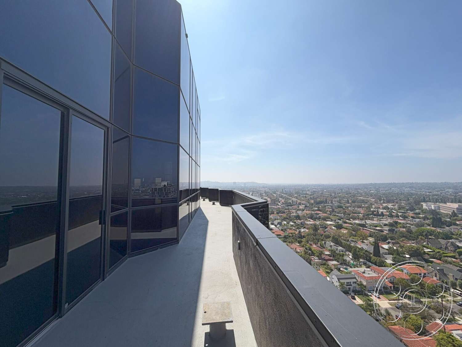 Wilshire Penthouse - exterior, flat roof, urban setting, glass facade, modern architectural style, city skyline view, aluminum railing, concrete balcony floor, black tinted windows