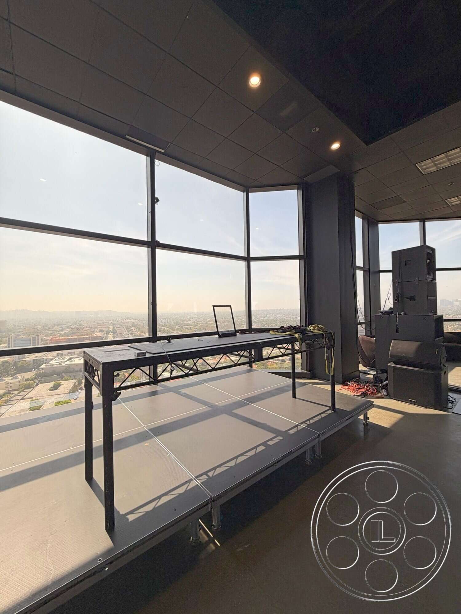 Wilshire Penthouse - concrete floor, exterior view, floor-to-ceiling windows, city skyline view, dark ceiling tiles, black metal stage