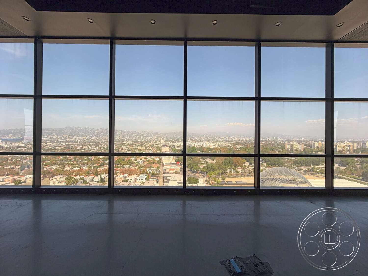 Wilshire Penthouse - high ceilings, natural light, open layout, concrete flooring, floor-to-ceiling windows, modern architectural style, city skyline view, suspended ceiling with recessed lighting, minimalist space