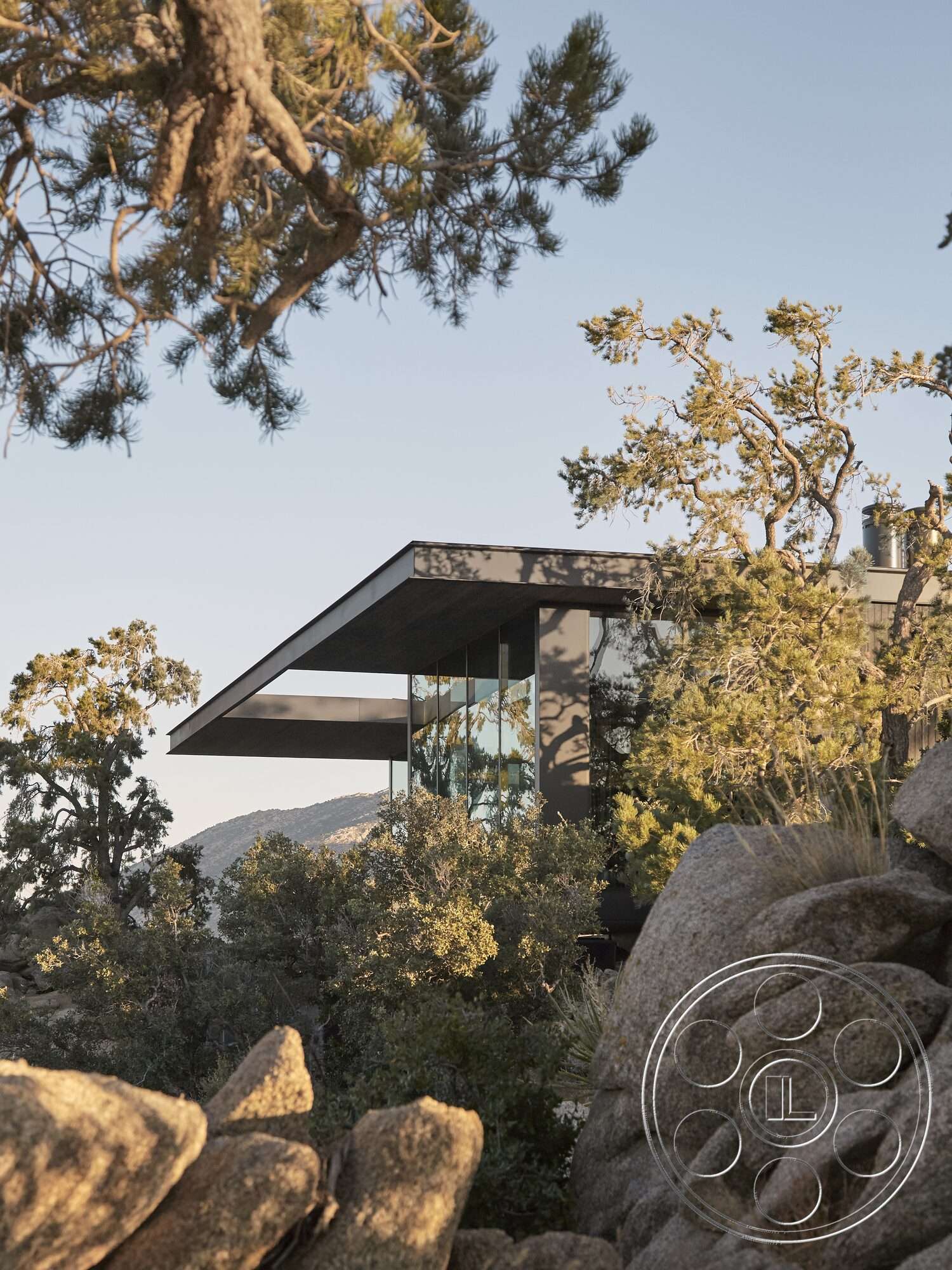 Palm Springs 110 - exterior, surrounding greenery, modern architectural style, mountain views, metal cladding, overhanging eaves, flat roof design, floor-to-ceiling glass windows, natural stone boulders, woodland setting