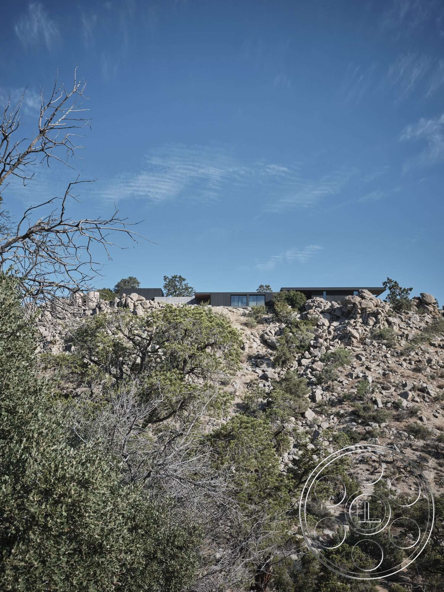 Palm Springs 110 - exterior, large glass windows, modern home, flat roof design, minimalist architectural style, natural stone foundation, surrounding desert vegetation, contoured rock landscape, integrated into hillside