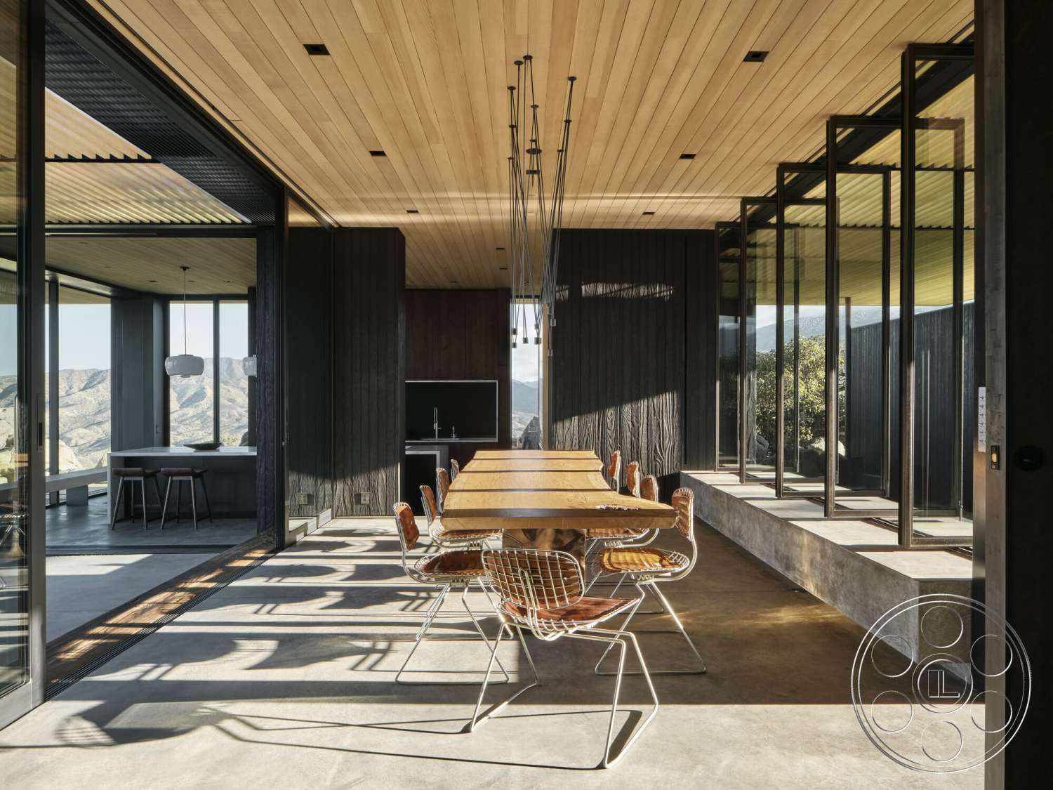 Palm Springs 110 - exterior, modern pendant lighting, glass walls, floor-to-ceiling windows, wood ceiling panels, large dining table, exposed concrete floor, open-plan layout, metal dining chairs, contemporary architectural style, mountain view setting, wood beam ceiling, built-in benches