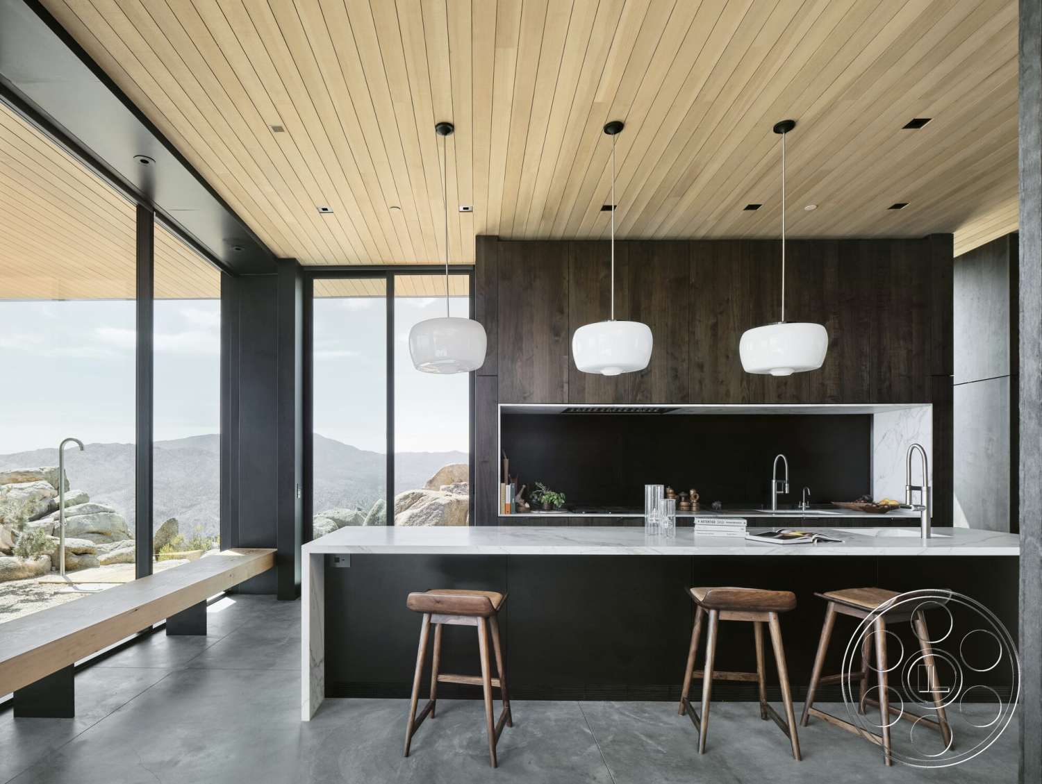 Palm Springs 110 - dark wood cabinetry, minimalist design, open concept layout, modern pendant lighting, floor-to-ceiling windows, marble kitchen countertops, wood beam ceiling, concrete kitchen flooring, natural stone window sills, built-in kitchen seating, black kitchen backsplash