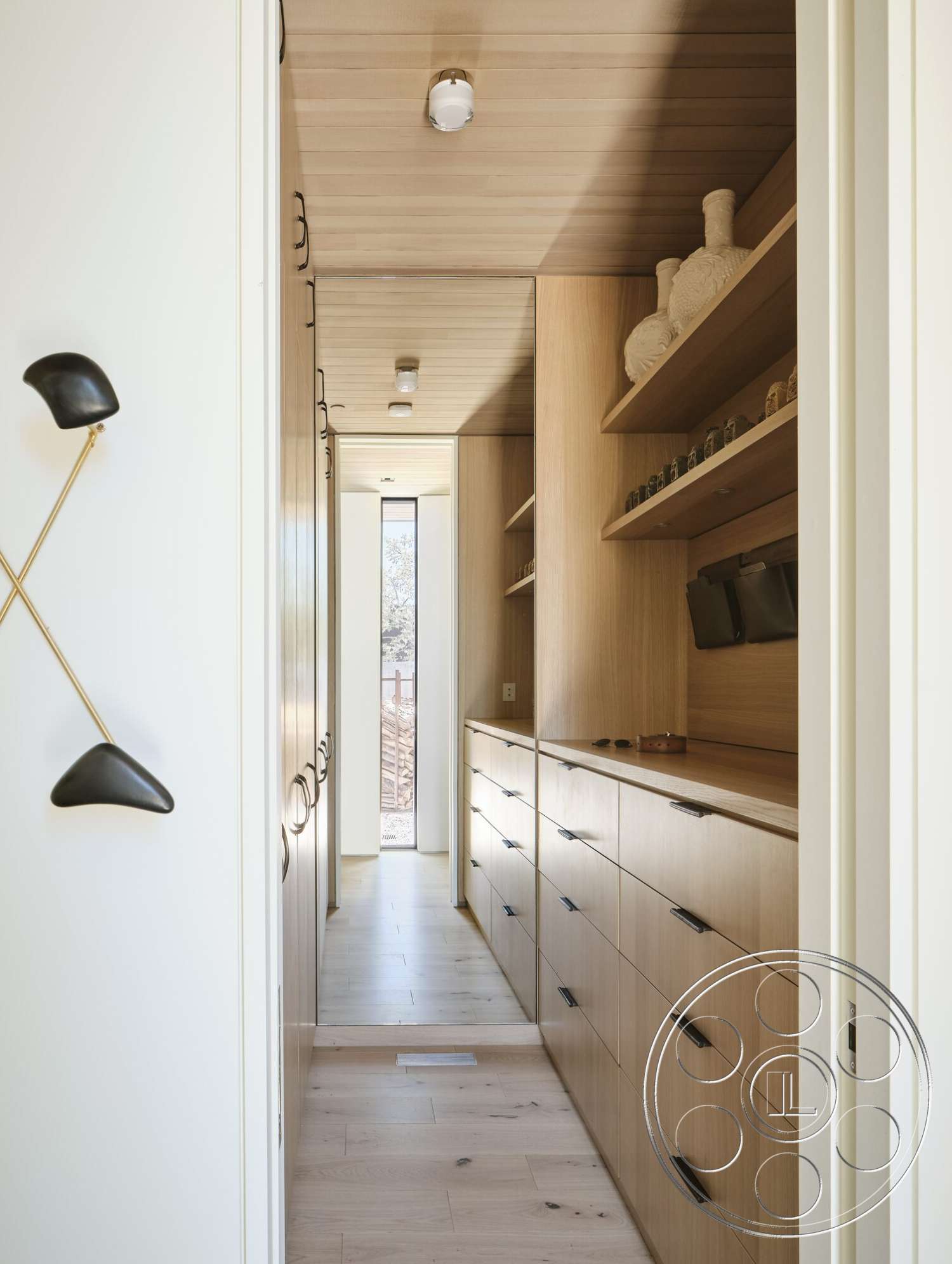 Palm Springs 110 - light wood cabinetry, floor-to-ceiling windows, plank flooring, narrow hallway, built-in storage cabinets, natural light corridor, wood ceiling planks, black hardware accents