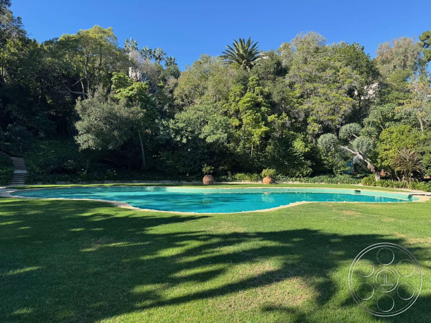 The Hearst House - exterior, surrounding trees, green foliage, tropical landscaping, stepping stone pathway, oval pool, concrete pool border, lawn grass