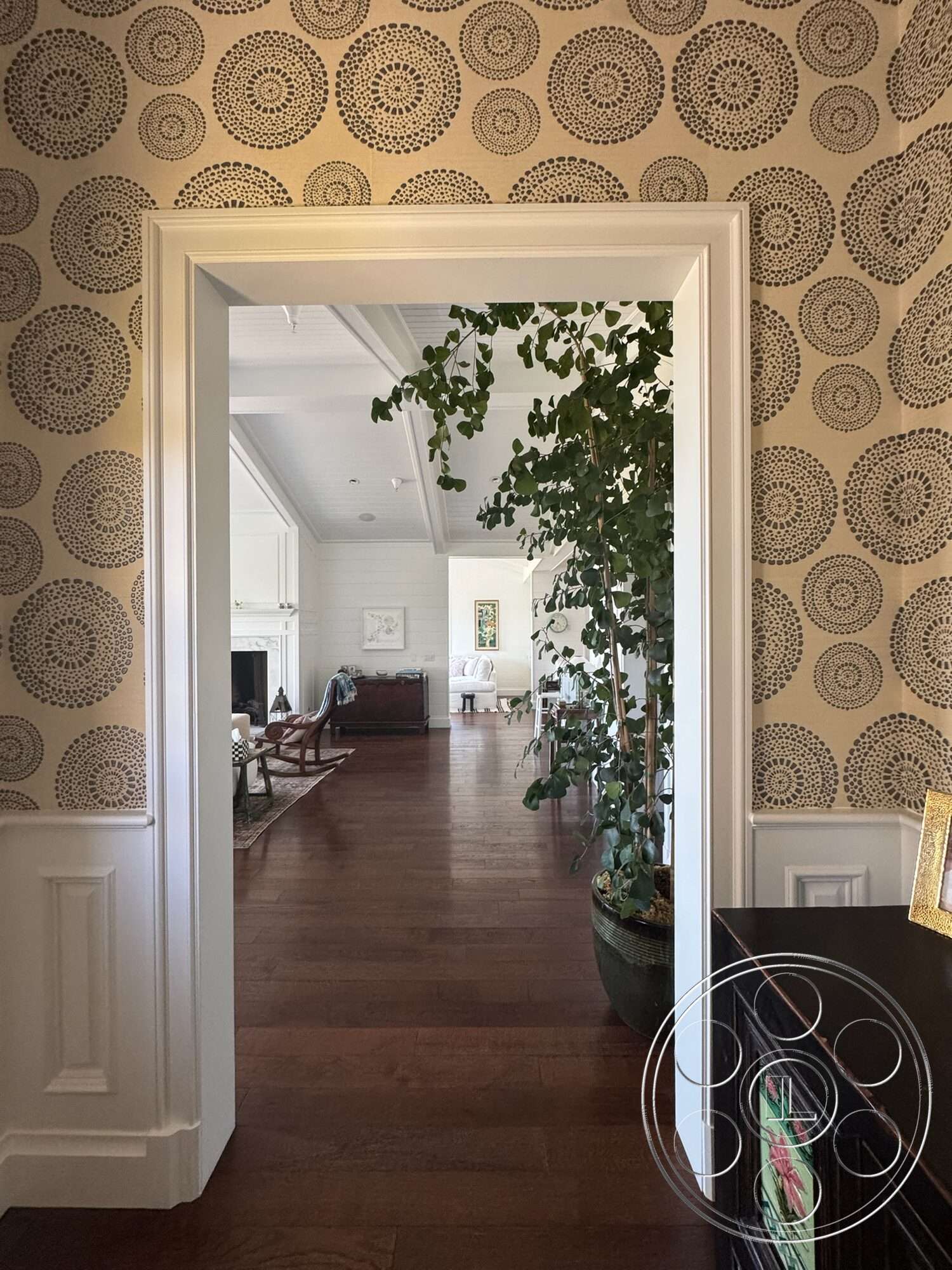 Americana 113 - natural light, hardwood flooring, open floor plan, modern furnishings, cozy living space, arched doorway, transom window, potted indoor plant, decorative wallpaper, ornate wall pattern, white trim molding, private hallway