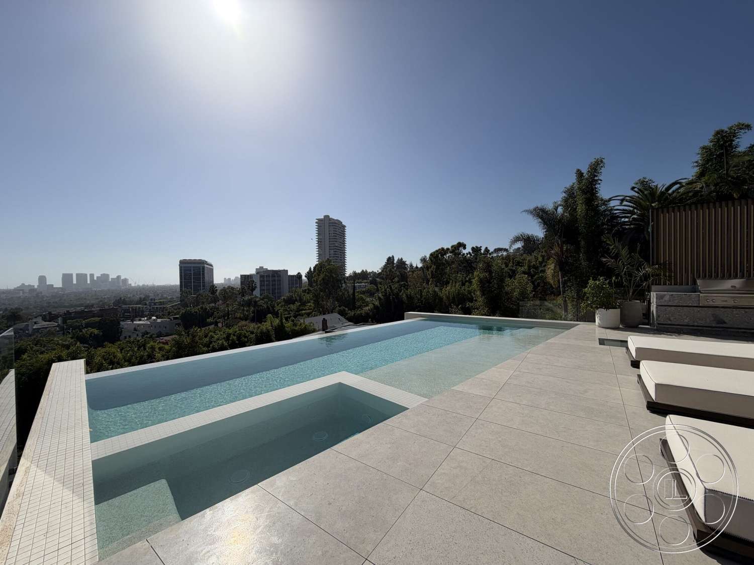 Modern 532 - concrete pool deck, large format stone flooring, surrounding hillside landscape, rectangular pool layout, urban skyline view in distance, outdoor lounge area with chaise lounges, exterior setting, infinity pool with tiled edge, floor-to-ceiling glass railing