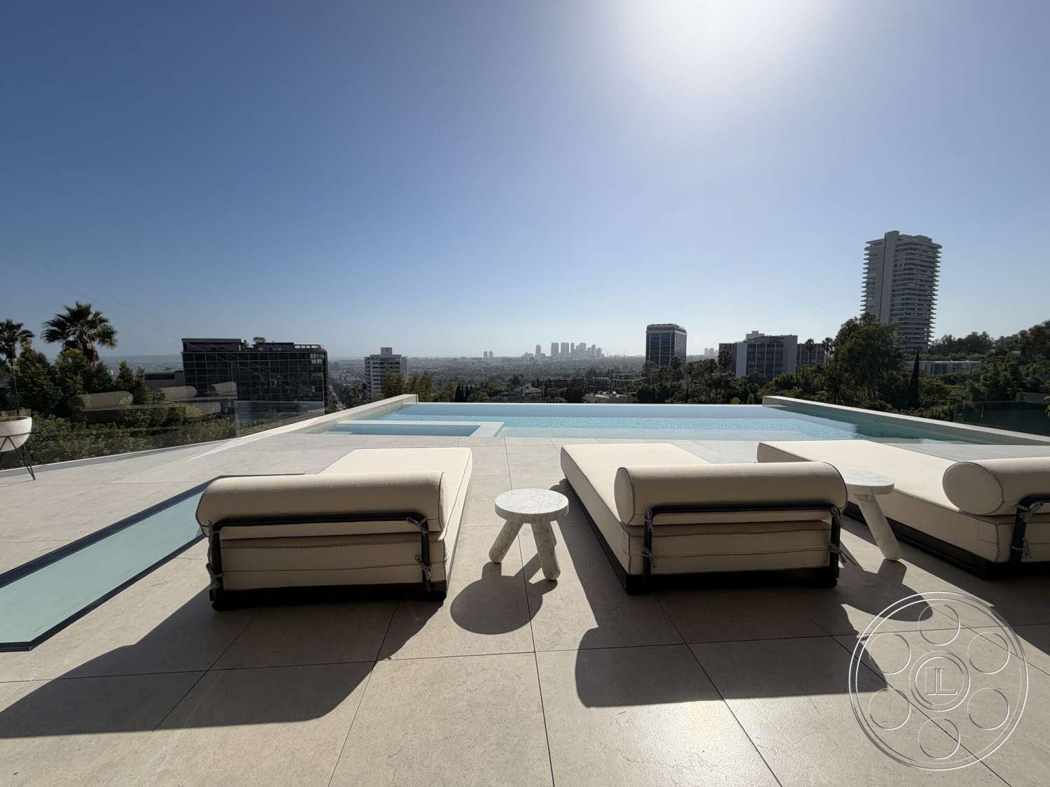Modern 532 - exterior, city skyline view, infinity pool, concrete pool deck, rectangular pool, sunny outdoor setting, modern lounge chairs, concrete patio flooring, glass pool edge, tile outdoor flooring