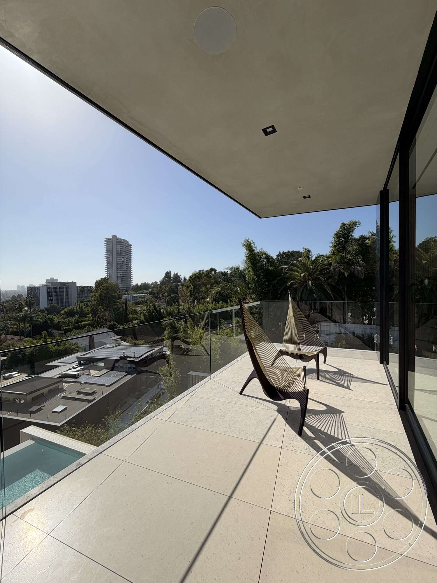 Modern 532 - exterior, outdoor seating area, modern architectural style, city skyline view, concrete patio flooring, glass balcony railing, smooth concrete ceiling, landscaped hillside environment, steel structural supports