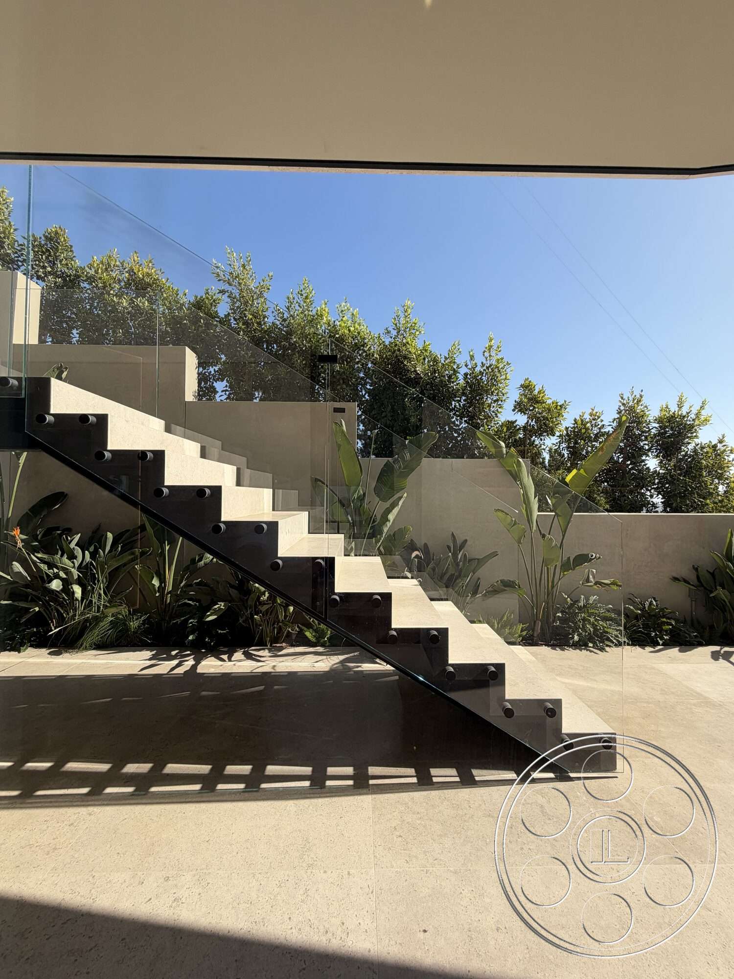 Modern 532 - natural light, concrete steps, floating staircase, textured concrete wall, minimalist architectural style, lush plant landscaping, glass stair railings, polished limestone flooring