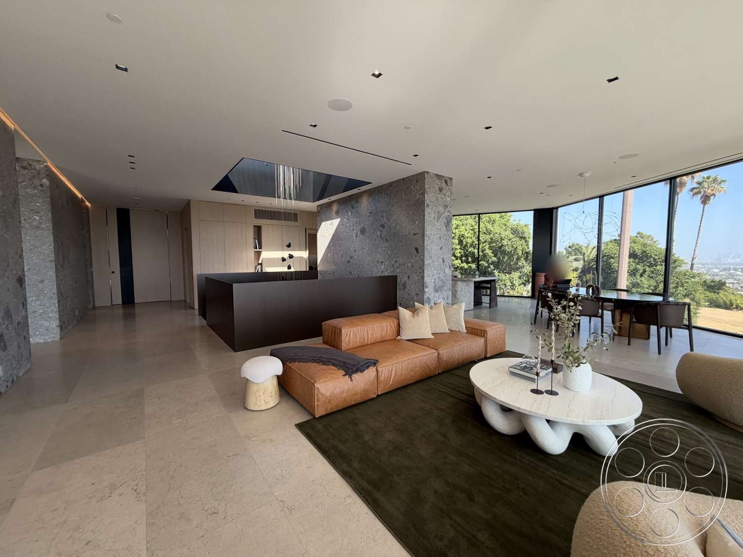 Modern 532 - natural light, open floor plan, light wood cabinetry, contemporary design elements, polished stone flooring, green area rug, lush outdoor view, minimalist dining area, floor-to-ceiling glass windows, exposed stone accent wall, ceiling-mounted recessed lighting, oversized leather sectional sofa, rounded marble coffee table