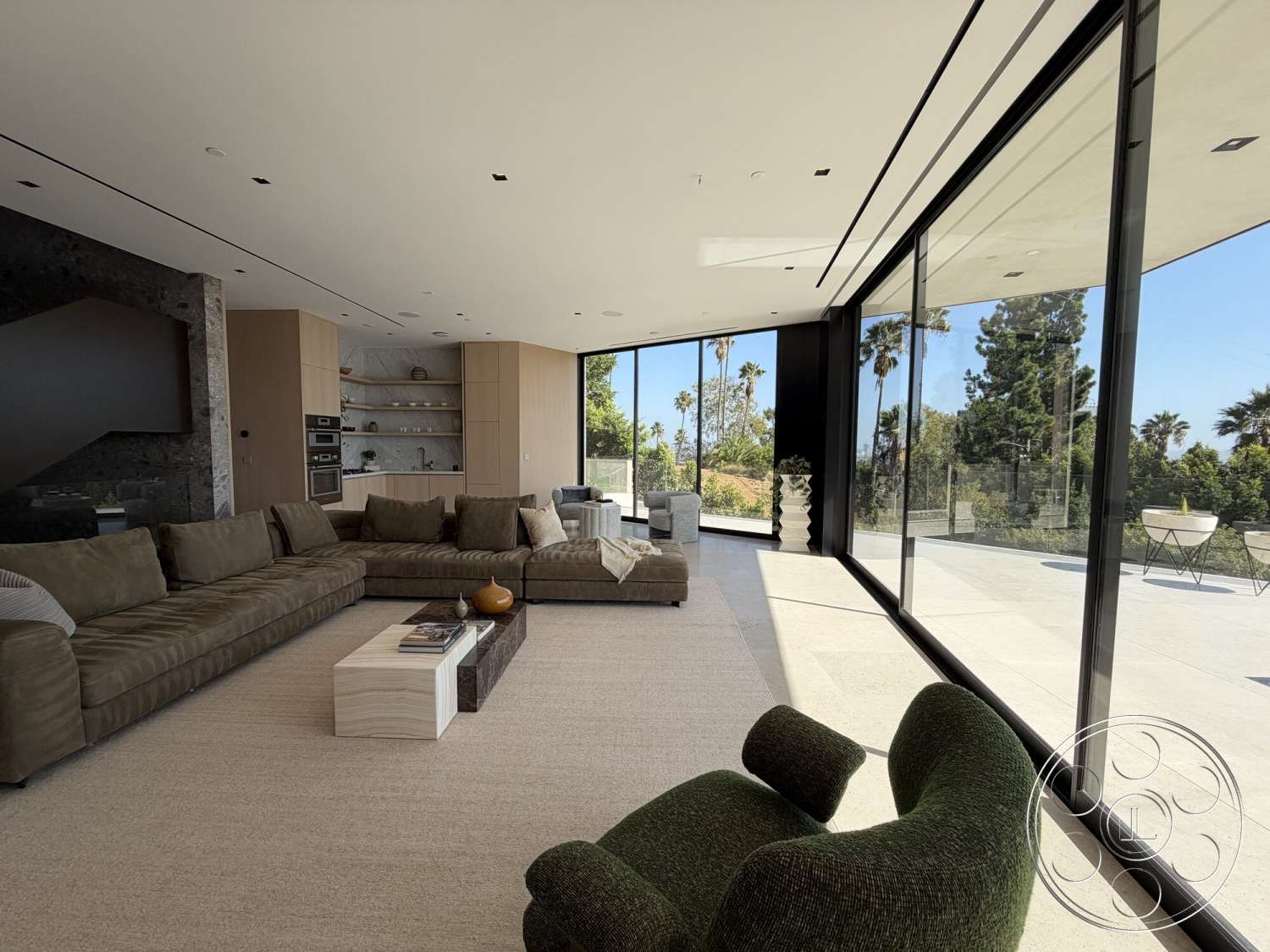 Modern 532 - minimalist design, concrete flooring, light wood cabinetry, floor-to-ceiling windows, marble coffee table, open concept living room, textured plaster walls, green accent chair, modern sectional sofa, natural light ambiance, linear ceiling lights, custom built-in shelves, outdoor view with palm trees