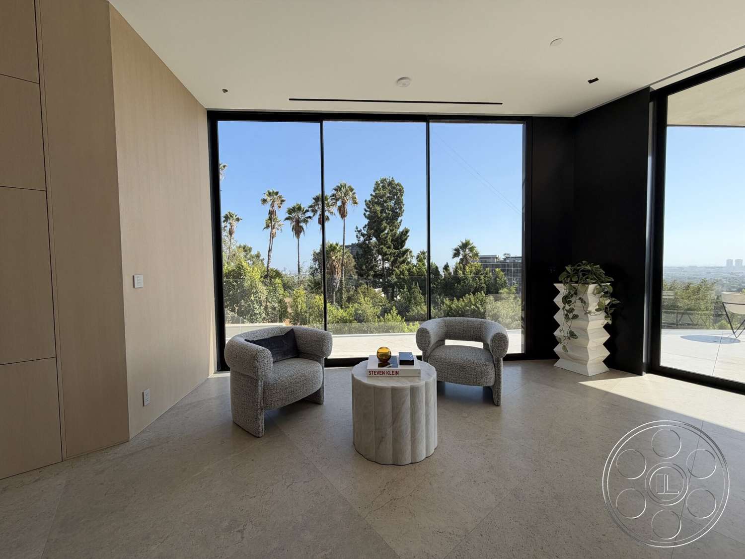 Modern 532 - contemporary design, open floor plan, natural stone flooring, panoramic views, bright and airy atmosphere, large floor-to-ceiling windows, black accent wall, upholstered armchairs, wood panel accent wall, modern circular coffee table, minimalist planters, luxury living area
