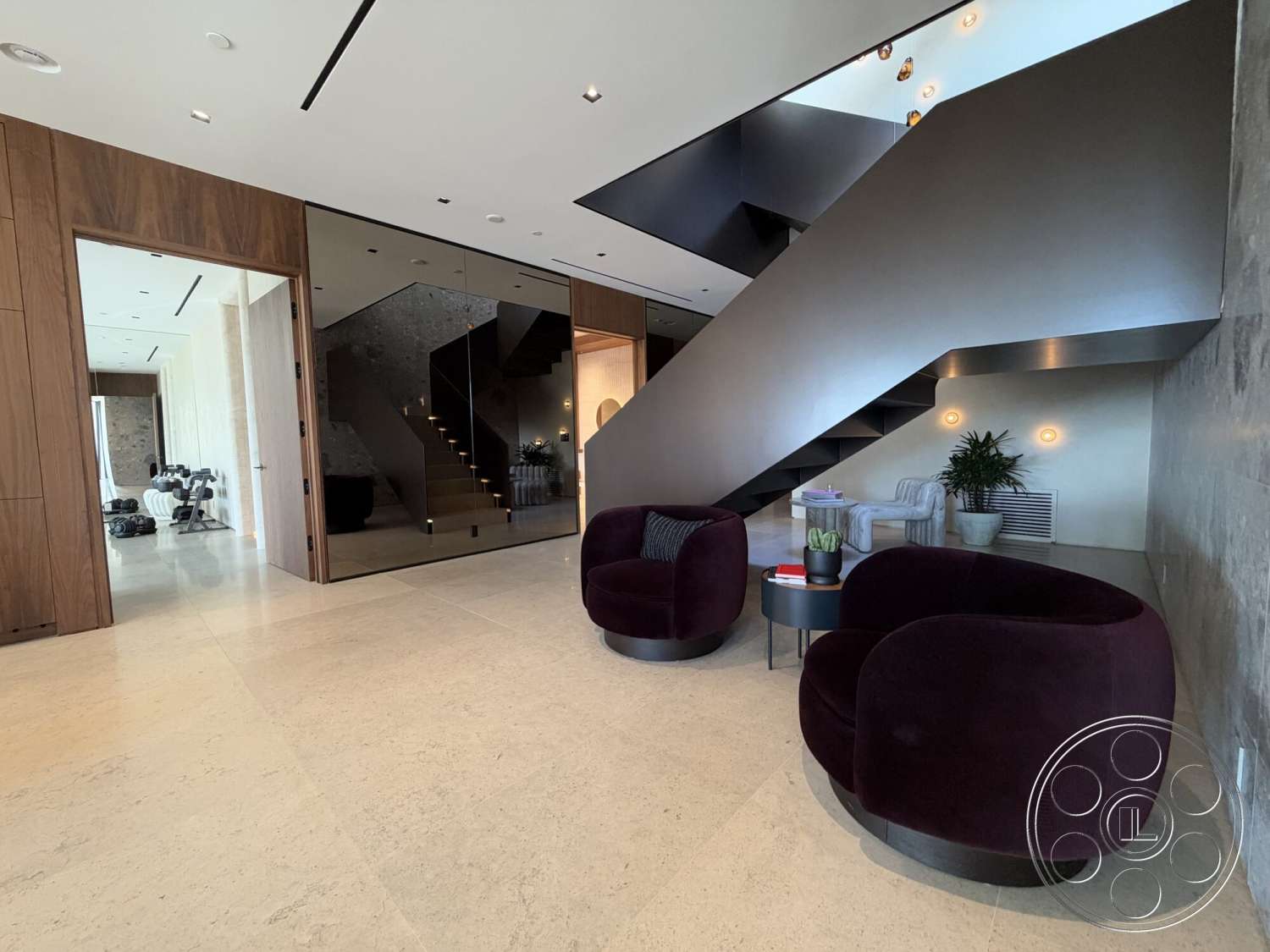Modern 532 - modern light fixtures, floor-to-ceiling windows, neutral color scheme, light-colored stone flooring, open floor plan layout, curved accent chairs, modern staircase design, dark wood wall paneling, glass stair railings, exposed ceiling lighting, contemporary round coffee table